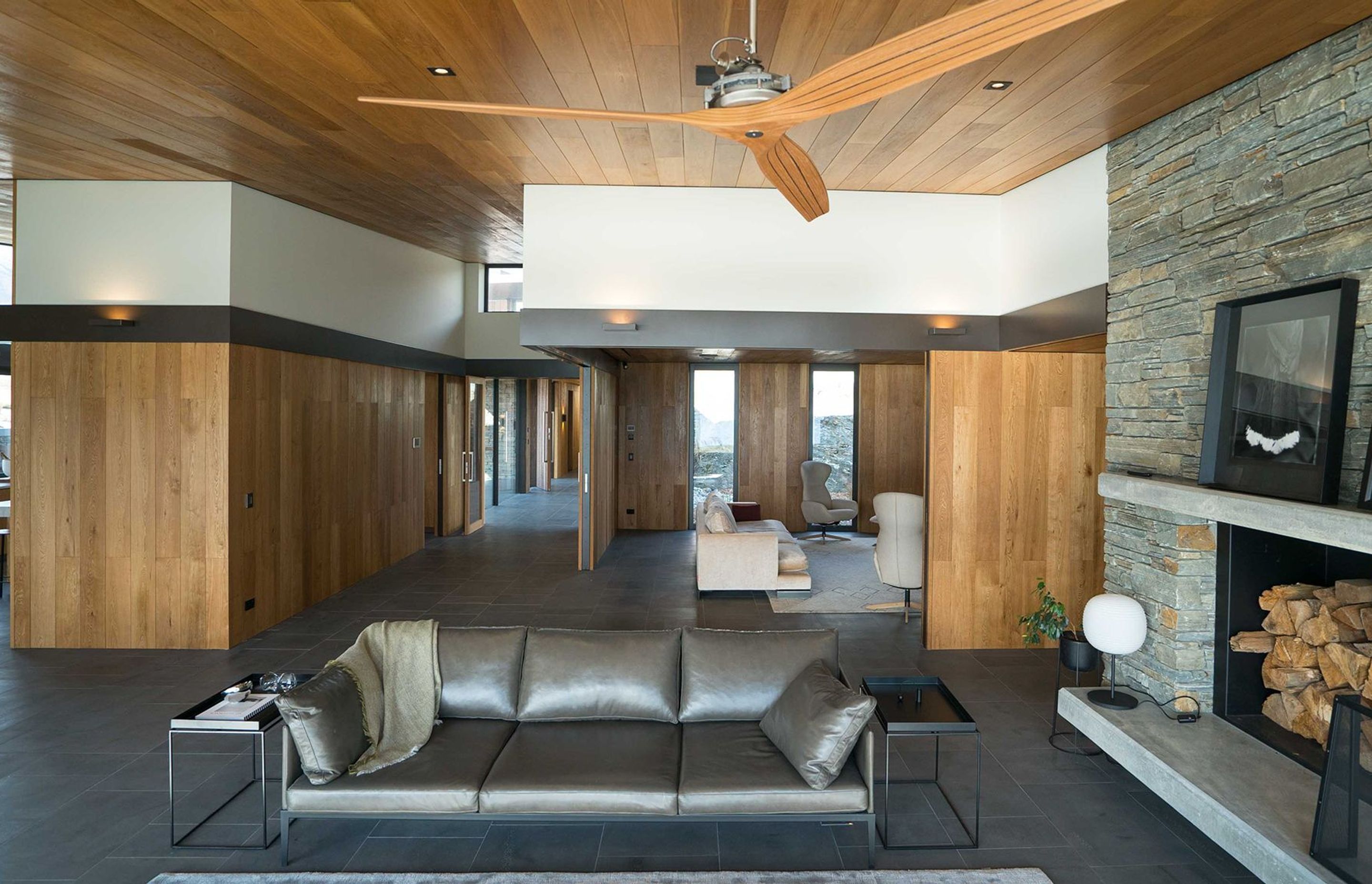 Oak-panelled walls and ceiling adds warmth to the Timaru bluestone flooring and Alexandra schist feature wall. Photograph: ArchiPro.