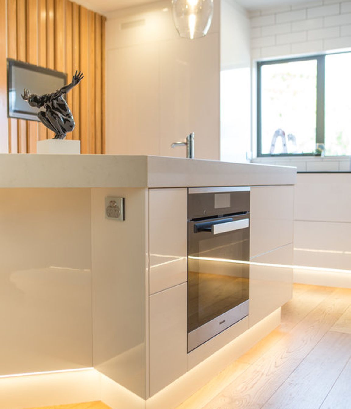 The kitchen is not unlike a commercial kitchen set up with a central prep bench, hot line behind and prep sink adjacent.