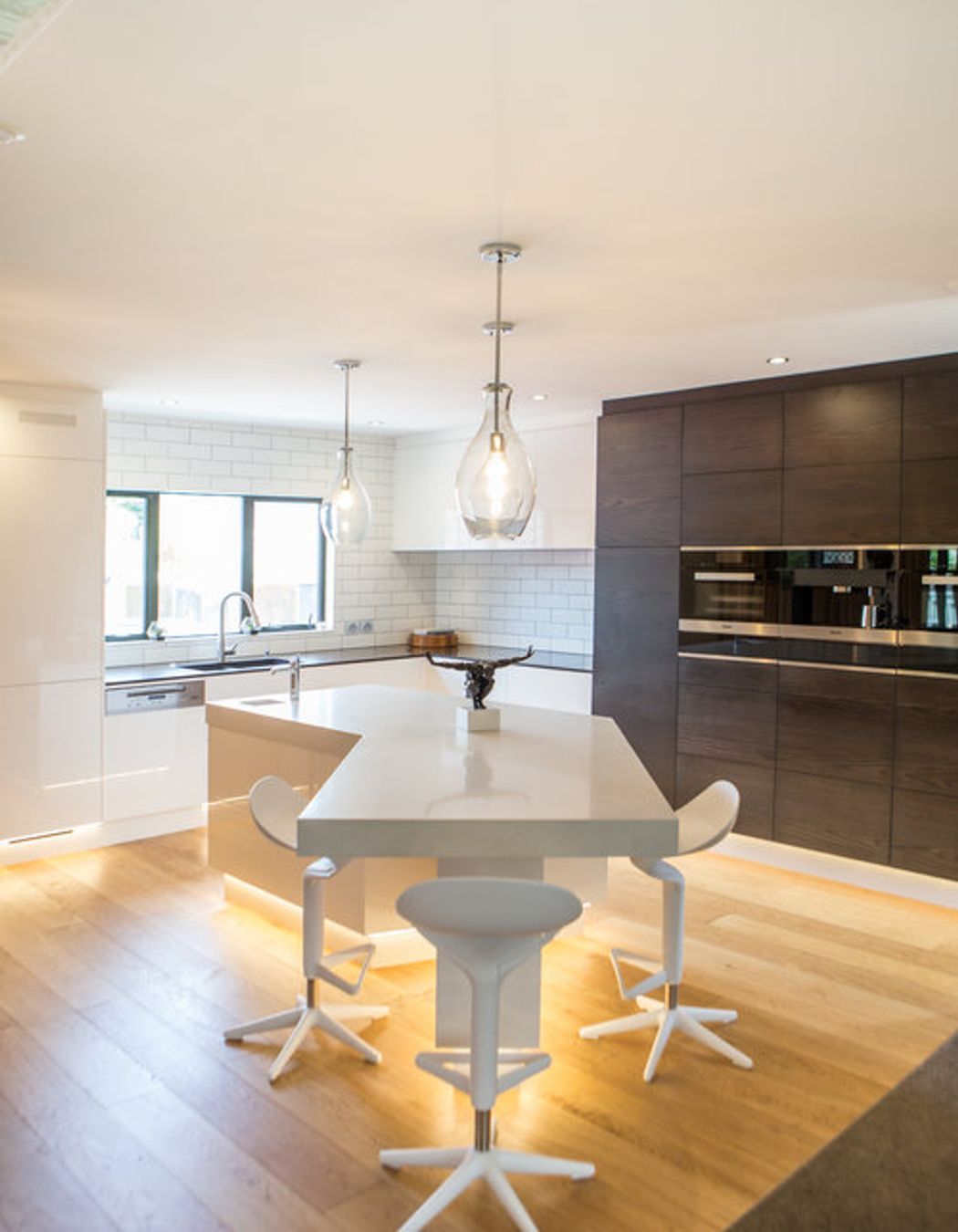 Feature LED downlighting in the kickspace elevates this high-tech kitchen.