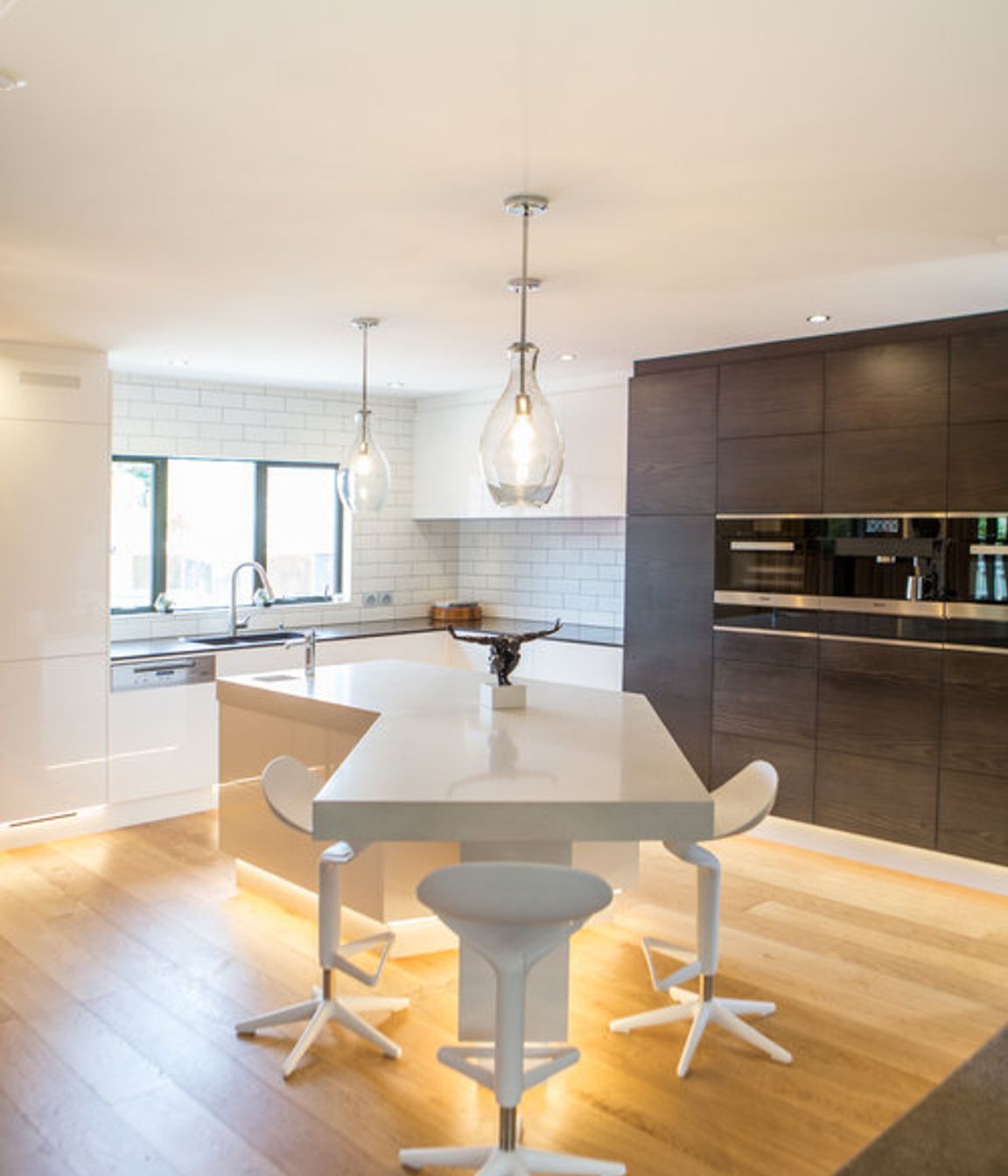 Feature LED downlighting in the kickspace elevates this high-tech kitchen.