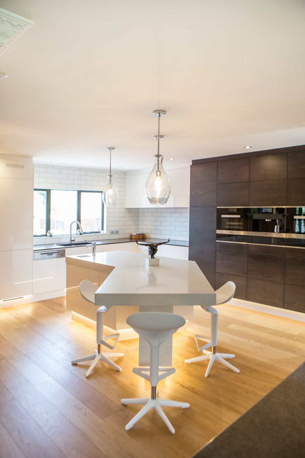 Feature LED downlighting in the kickspace elevates this high-tech kitchen.