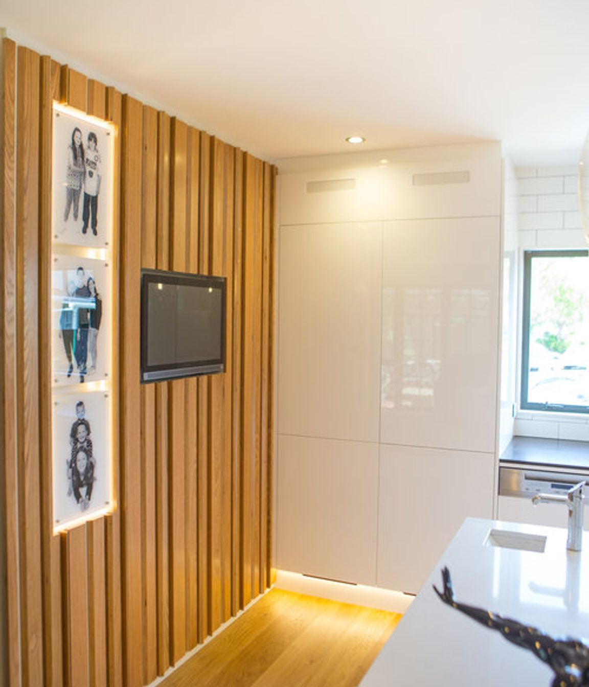 This was a unique response to the client’s brief - an oak plywood slatted divider wall, which brings the family’s personality to the space through an inset touch screen computer and digital photo frames.