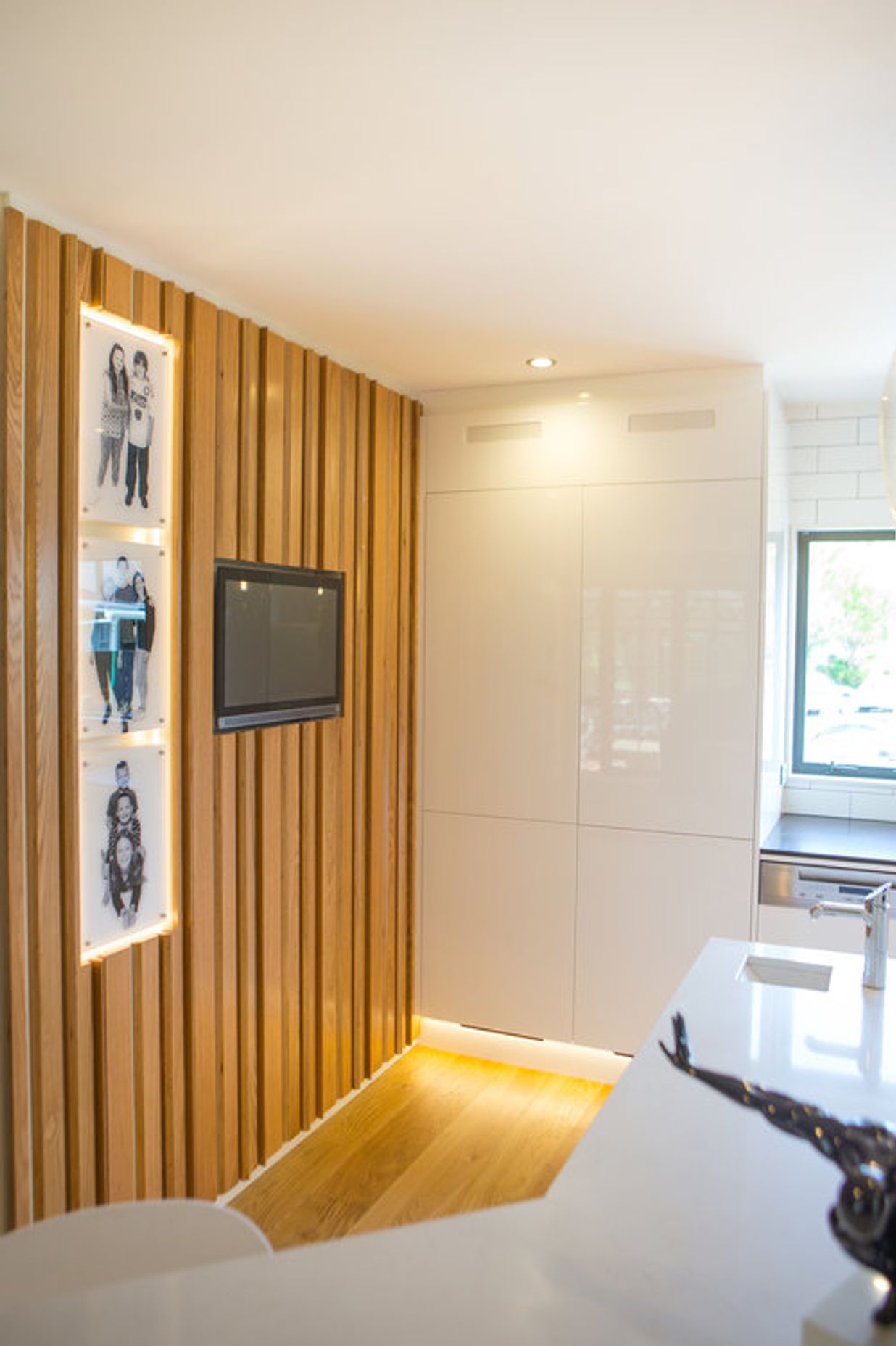 This was a unique response to the client’s brief - an oak plywood slatted divider wall, which brings the family’s personality to the space through an inset touch screen computer and digital photo frames.