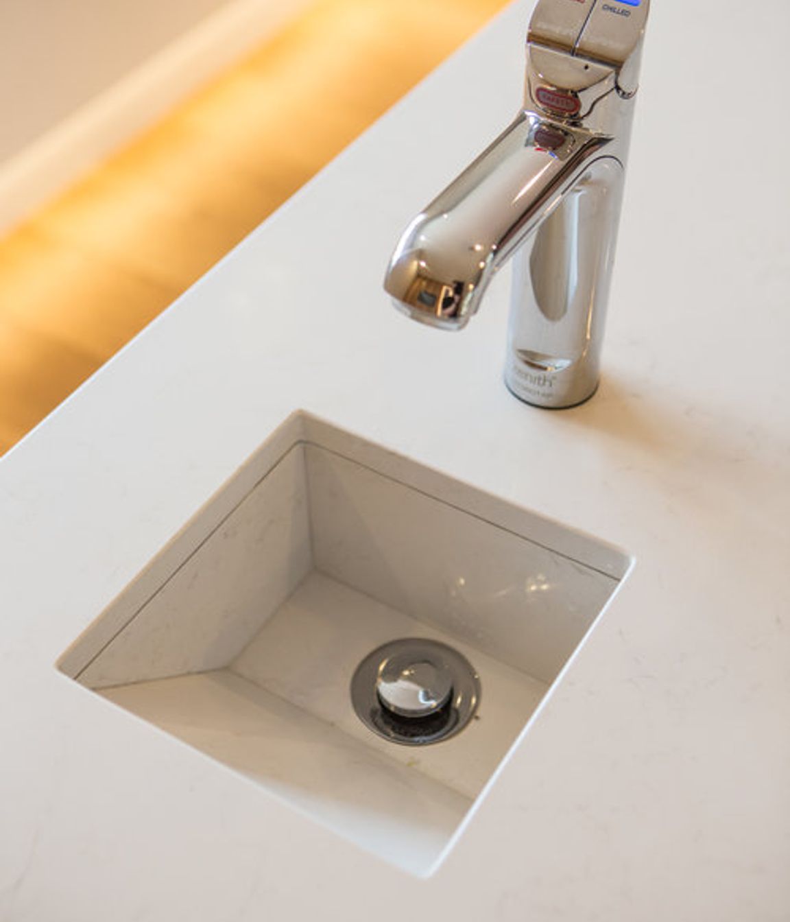 A custom stone drip-sink was designed into the island benchtop to work with a Zenith hydro tap which supplies boiling, filtered, and sparkling water.