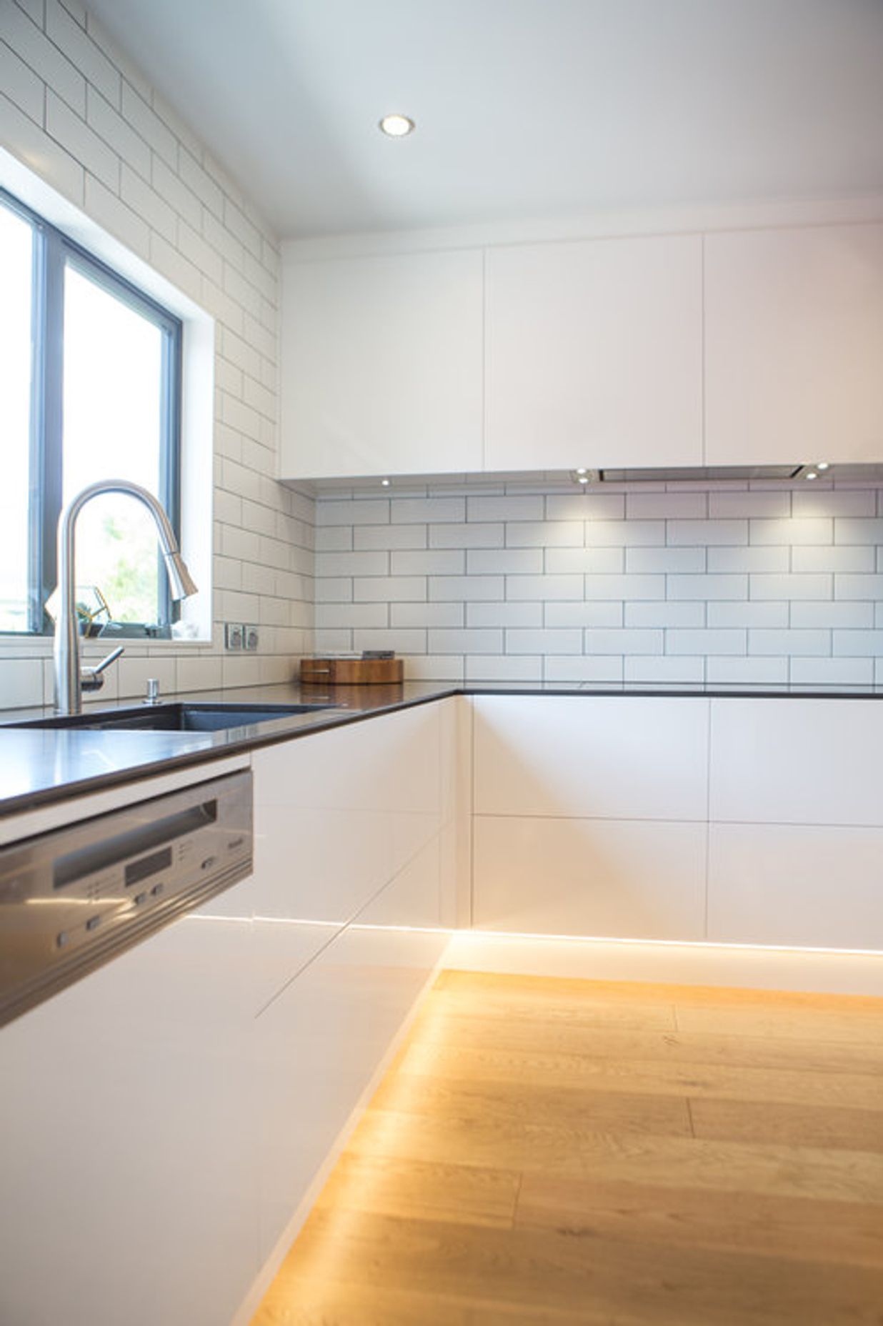 Clean lines, slim Caesarstone benchtops and handleless gloss cabinetry.