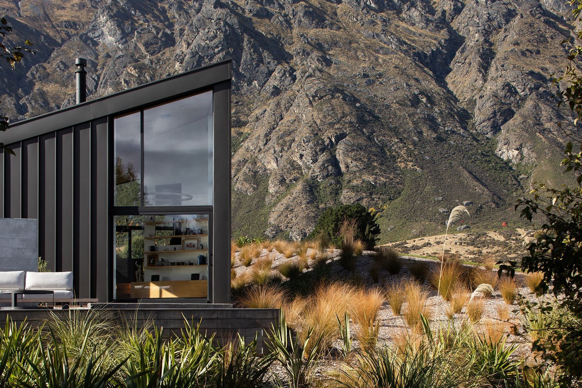 The asymmetrical form and recessive metal cladding is designed to match the schist of the surrounding rocky landscape.