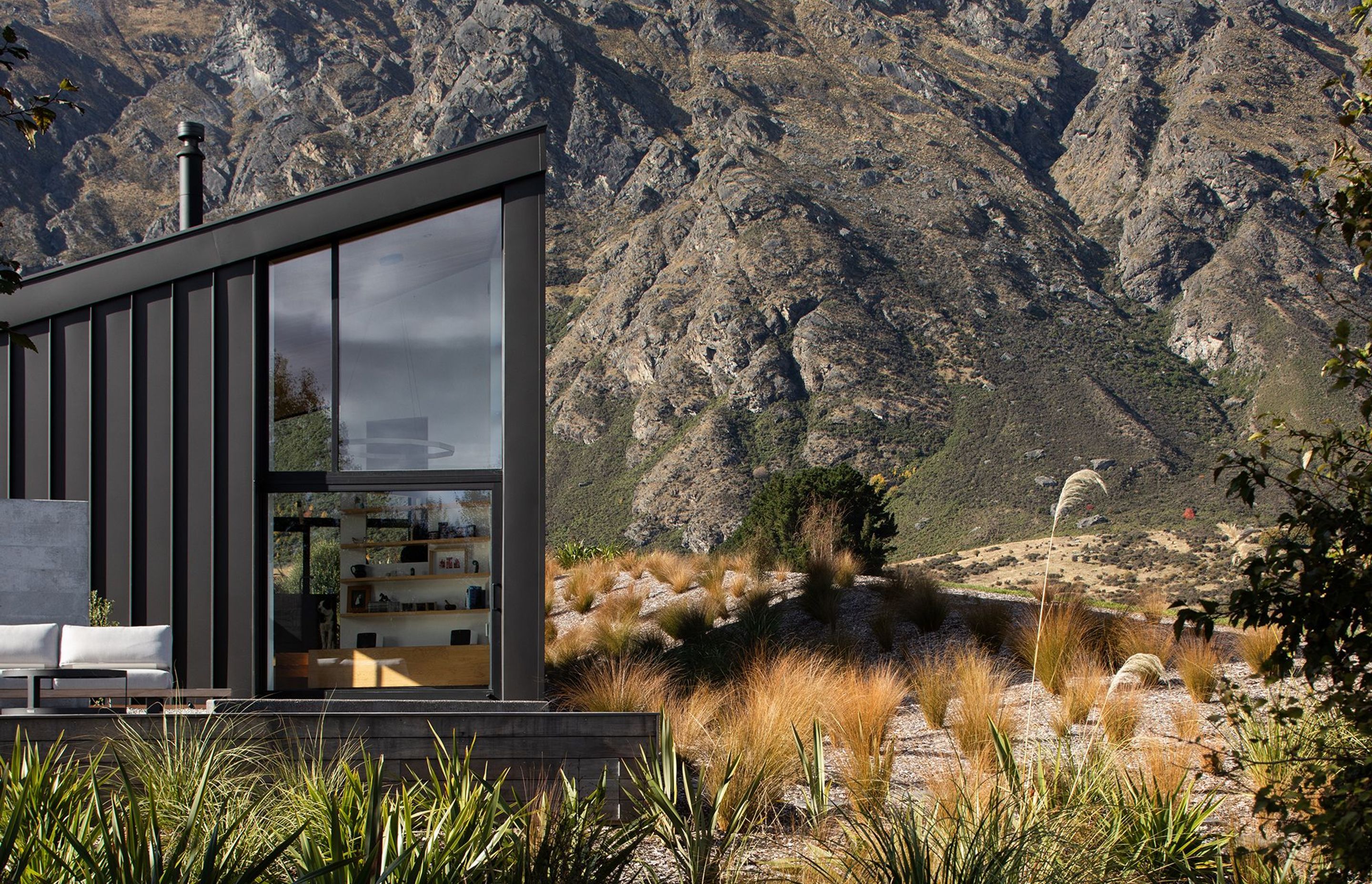 The asymmetrical form and recessive metal cladding is designed to match the schist of the surrounding rocky landscape.