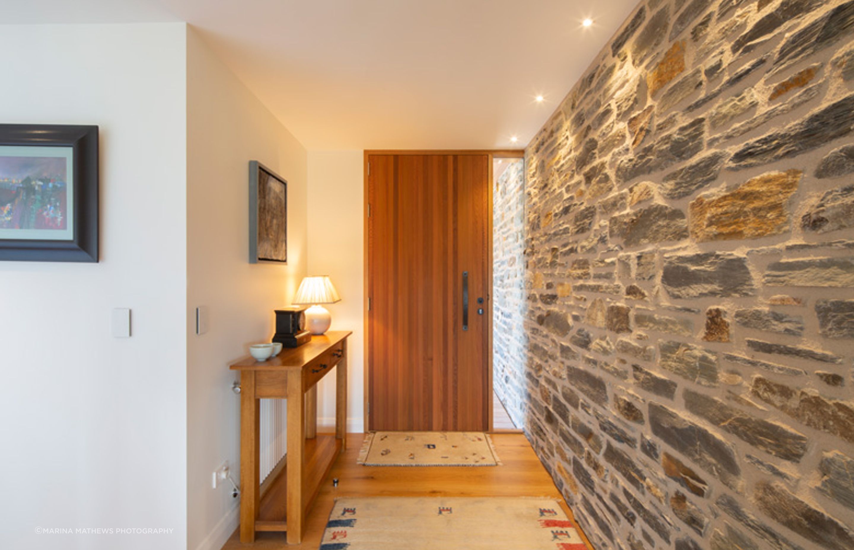 The bagged stone cladding has been continued inside to create an impressive feature wall in the entryway.