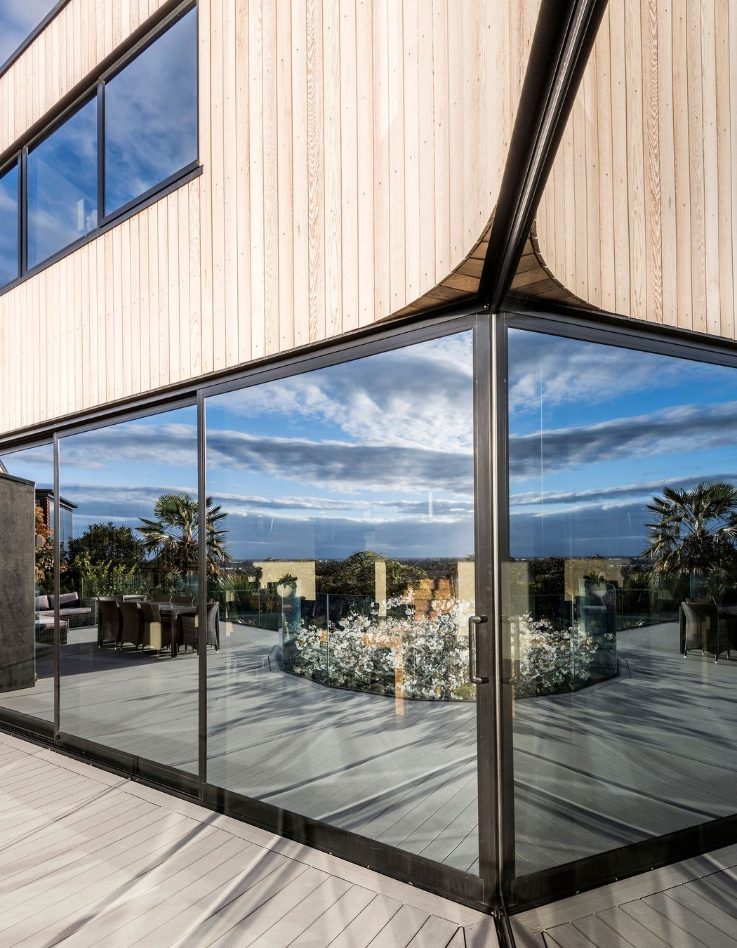 Tinted mirrored glass draws the landscape onto the glazed areas of the home.