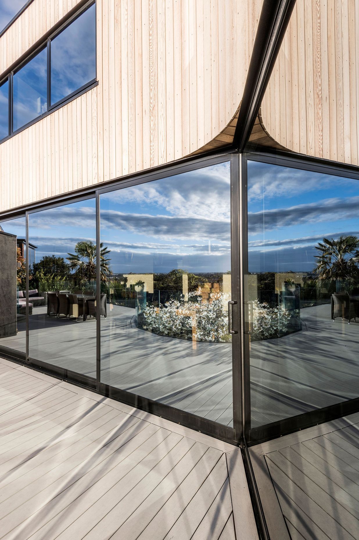 Tinted mirrored glass draws the landscape onto the glazed areas of the home.