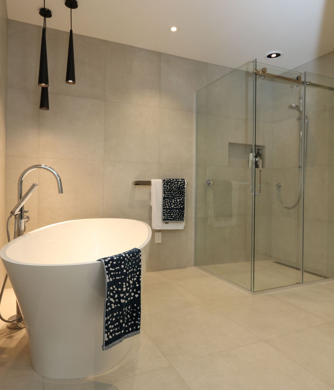 The main bathroom exerts just as much wow-factor as the ensuite with its large frameless glass shower and luxurious bath set-up.
