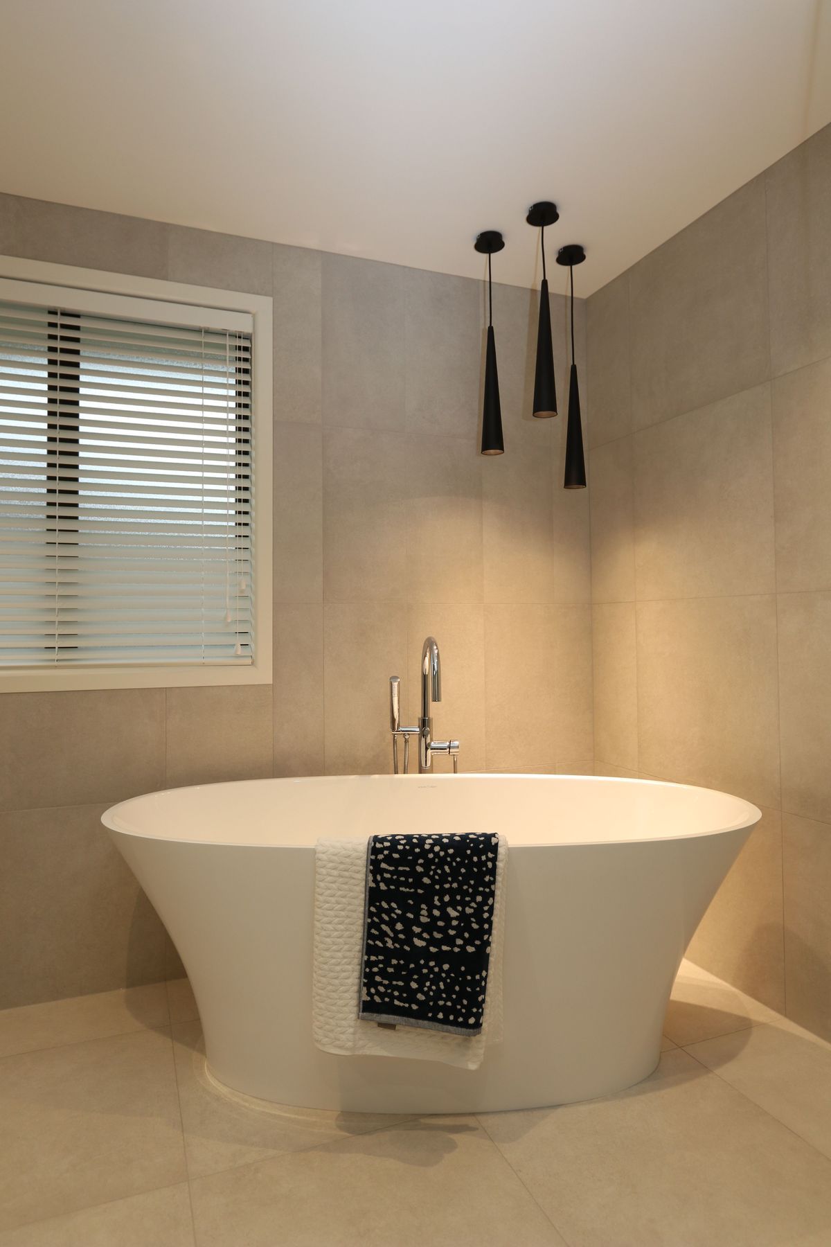 The main bathroom in this clients home features a matching theme with the same feature bath creating a statement with the gorgeous free-standing bath filler.