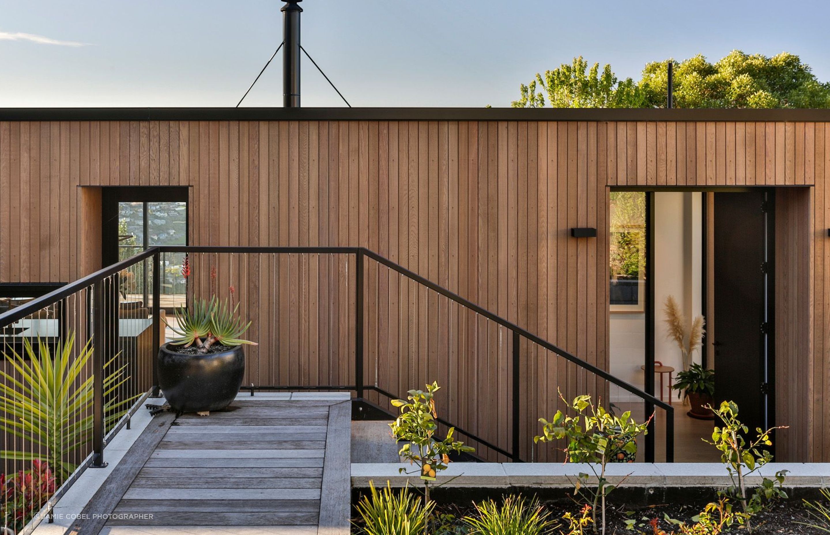 Sitting on a steep and challenging hill site, the front entrance is via stairs from the driveway above.