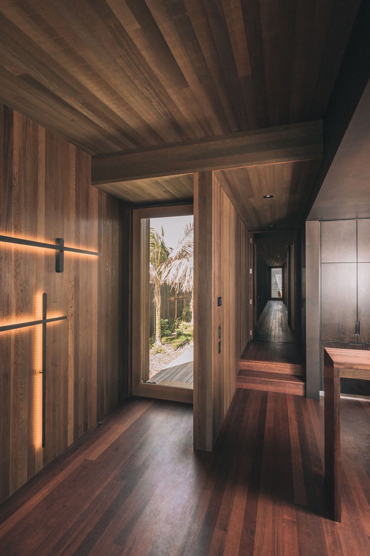 The interiors are dominanted by rich timber and deep tones, unusual for beachside homes.