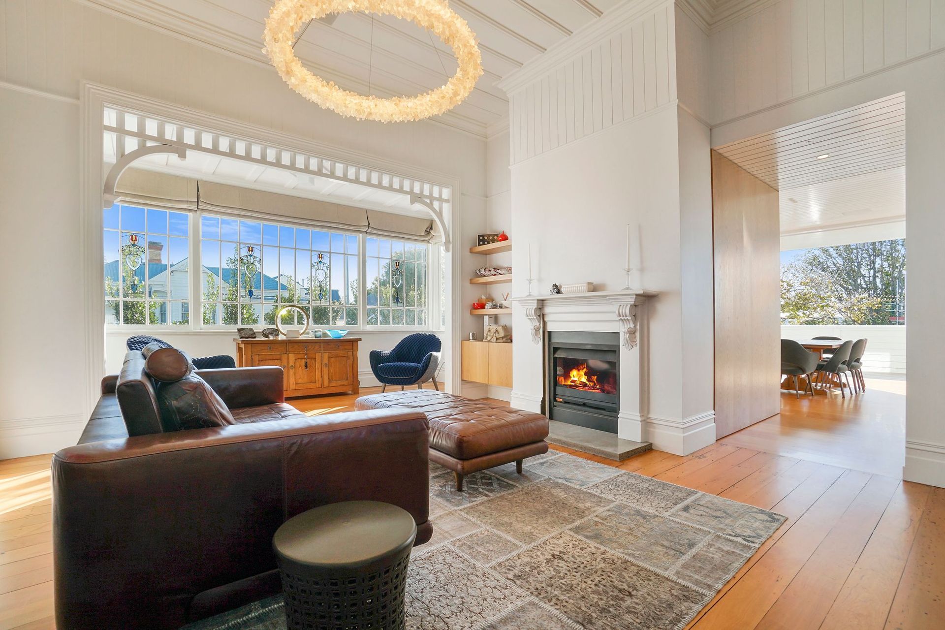 The home has been treated to a loving restoration by the builders, with mindful timber work seen throughout the front of the house. This is exhibited in the upstairs living room, where the beautiful villa meets a luxurious twist, with decadent crystal lighting conversing with Kauri flooring and vintage led light windows.