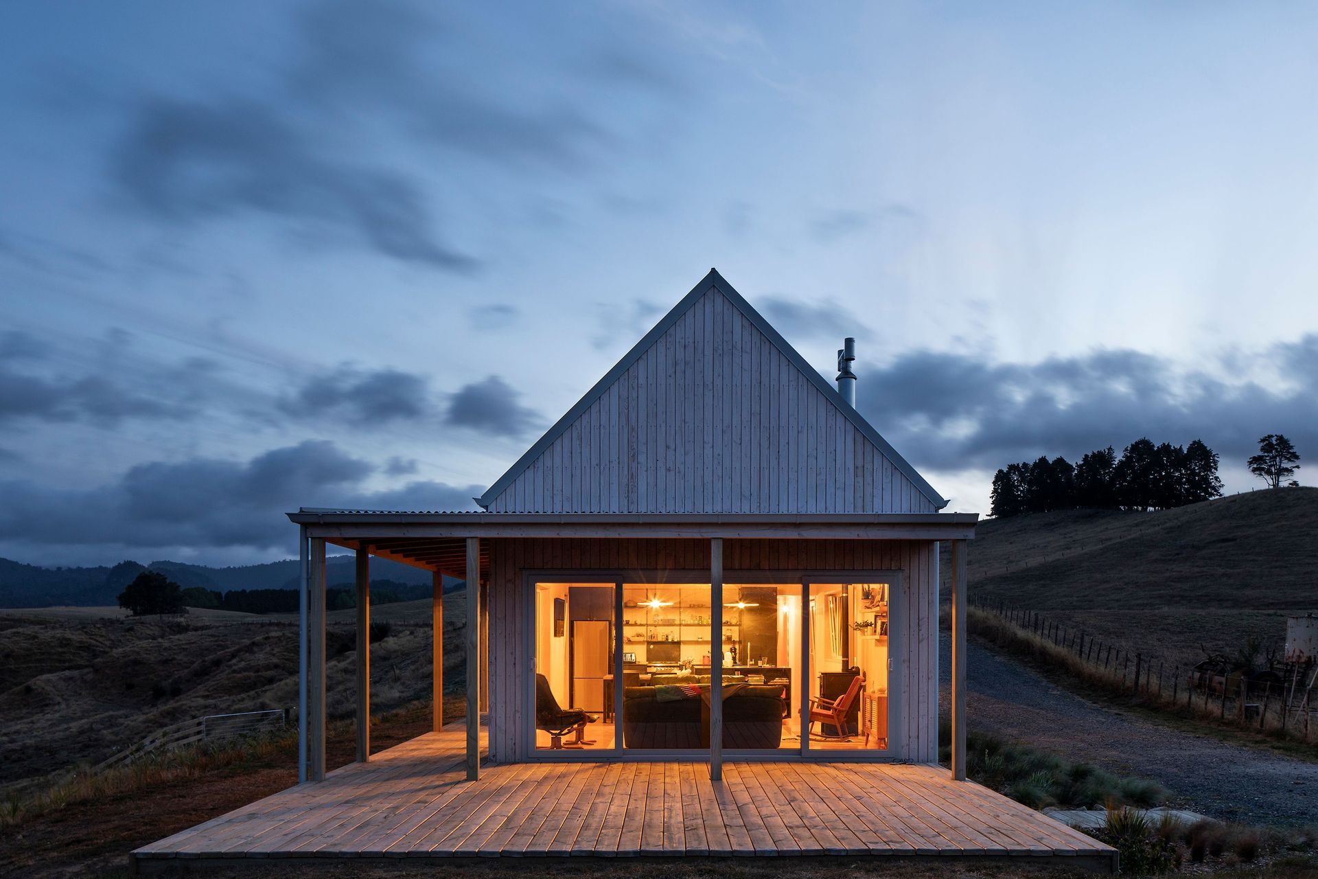 The southern gable end of the main living area lit up at dusk.