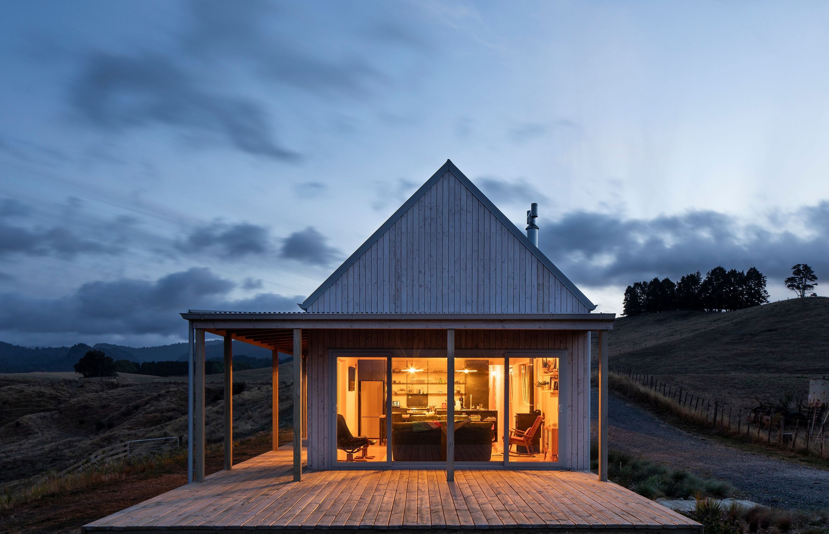 The southern gable end of the main living area lit up at dusk.