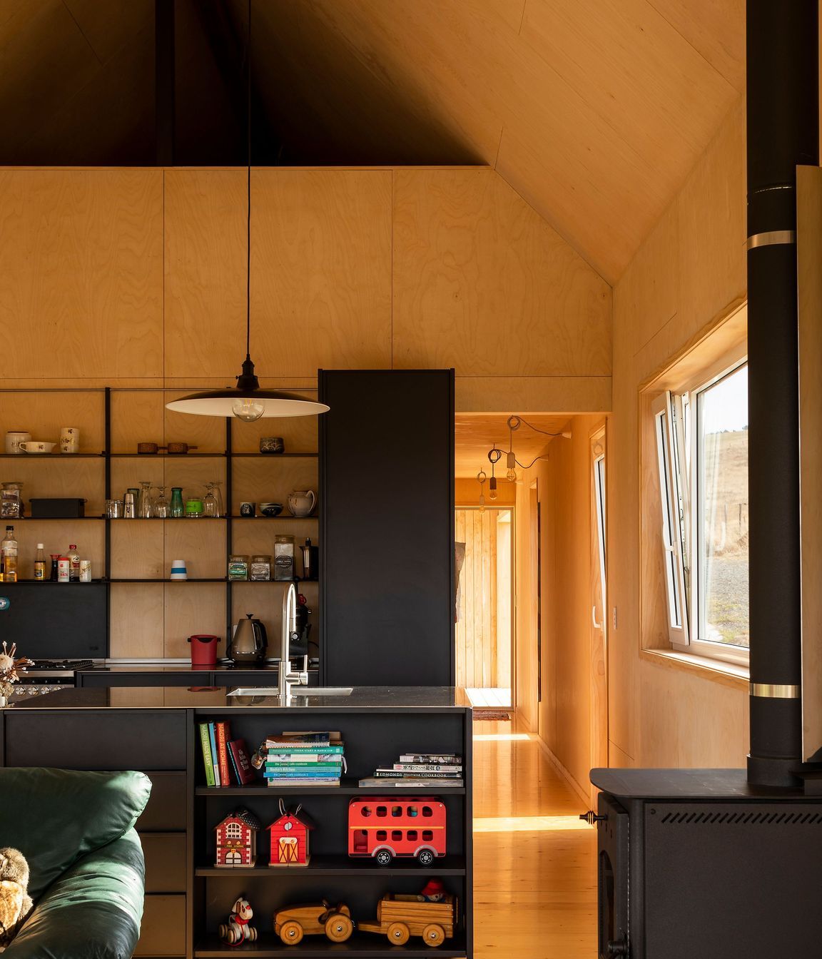 An all-black kitchen provides a strong contrast against the light timbers.