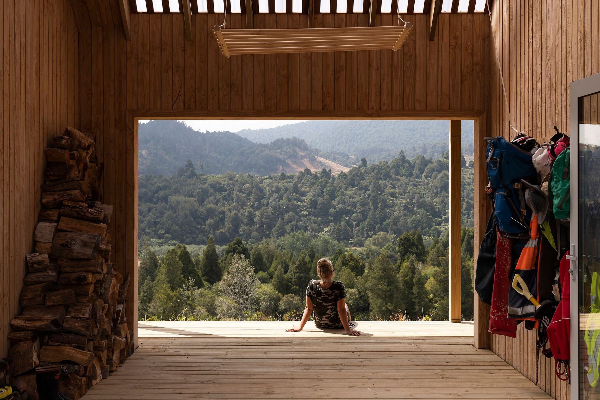 A sunny view of bush-clad hills from the timber-clad outdoor room.