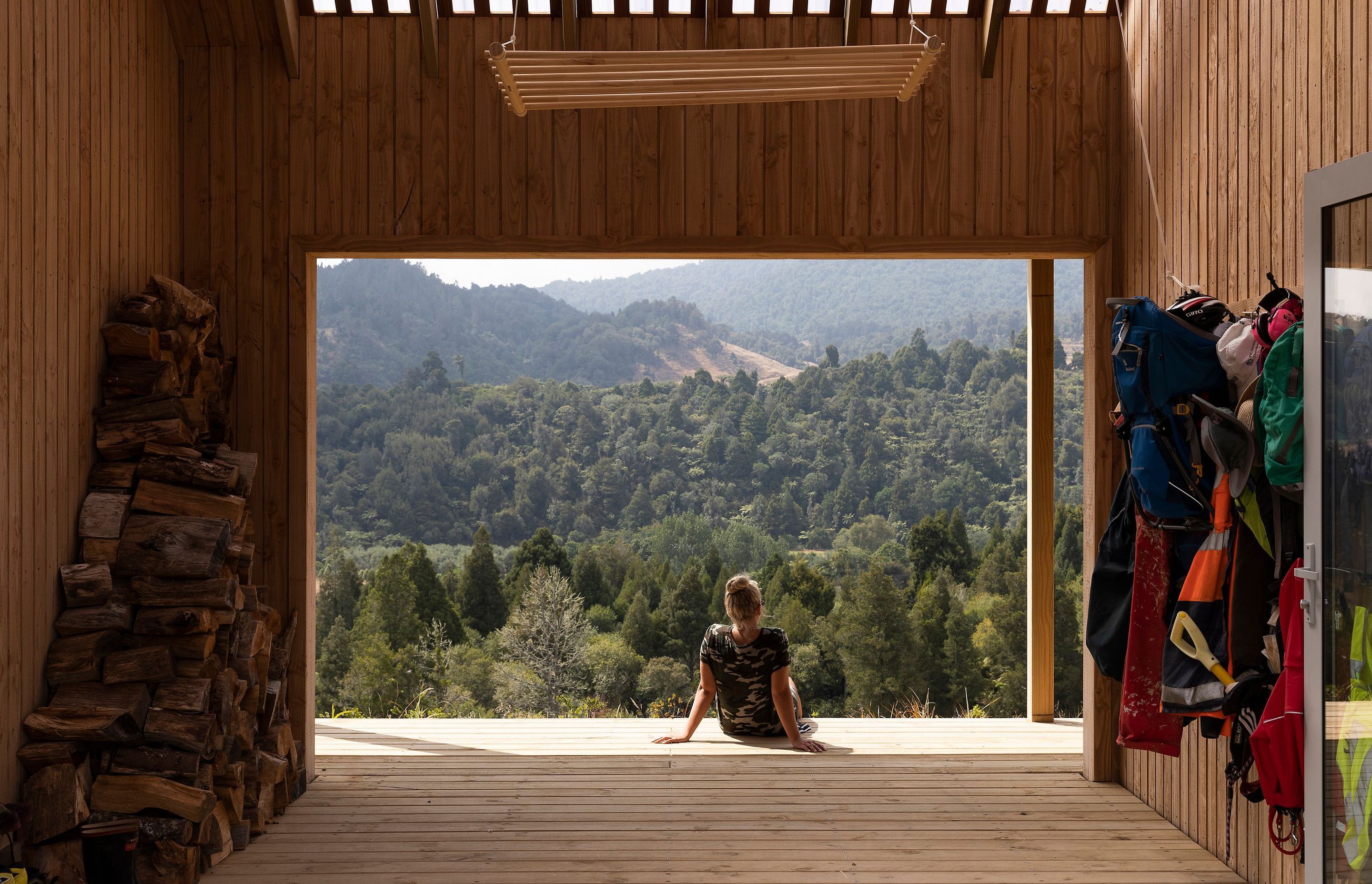 A sunny view of bush-clad hills from the timber-clad outdoor room.