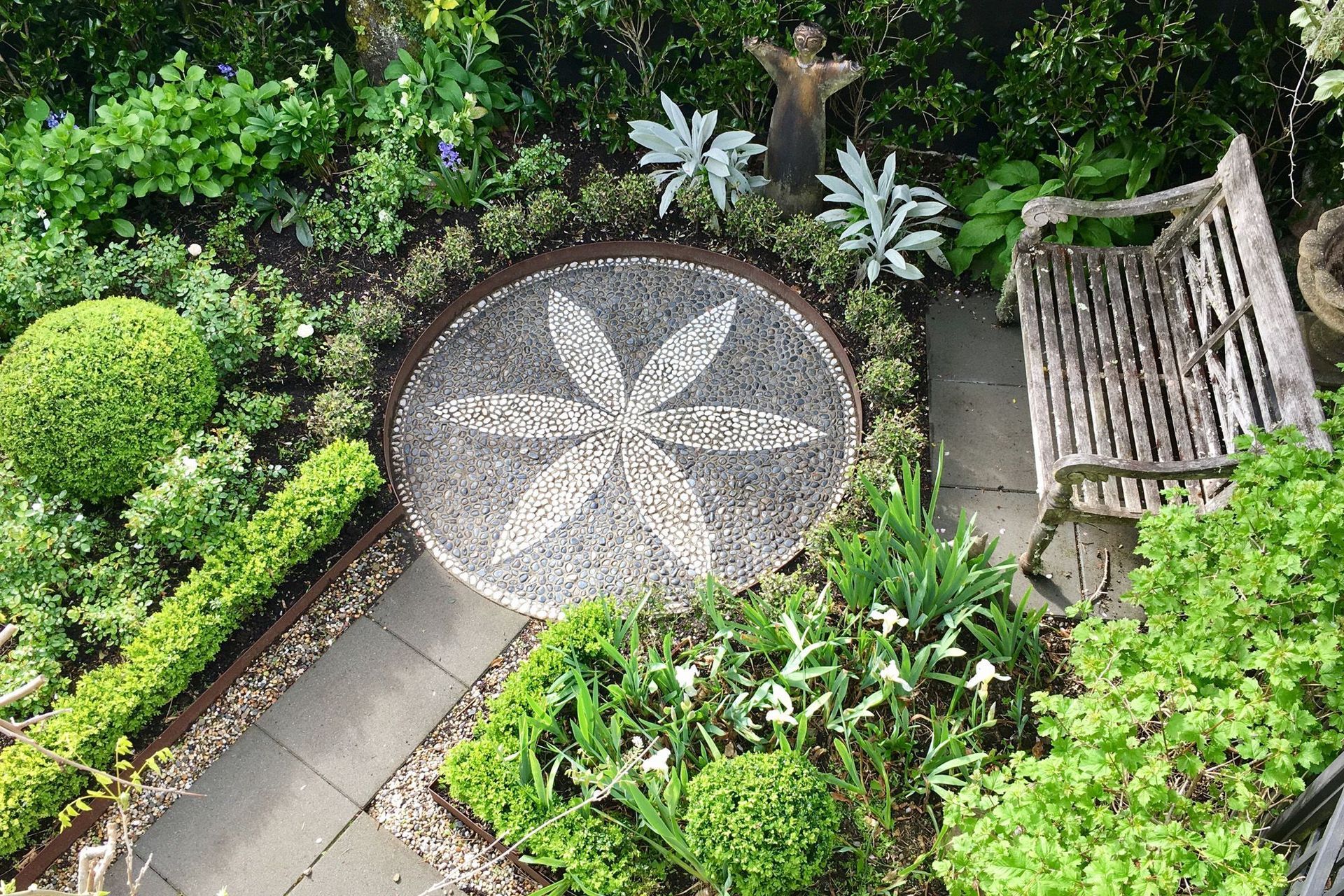 Stone mosaic set in CorTen steel surrounded by seat and iris garden