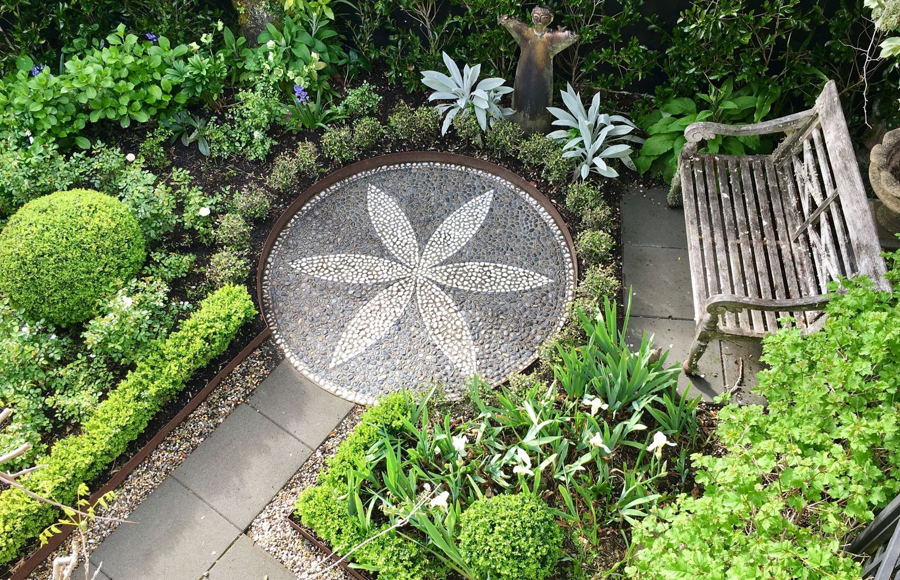 Stone mosaic set in CorTen steel surrounded by seat and iris garden