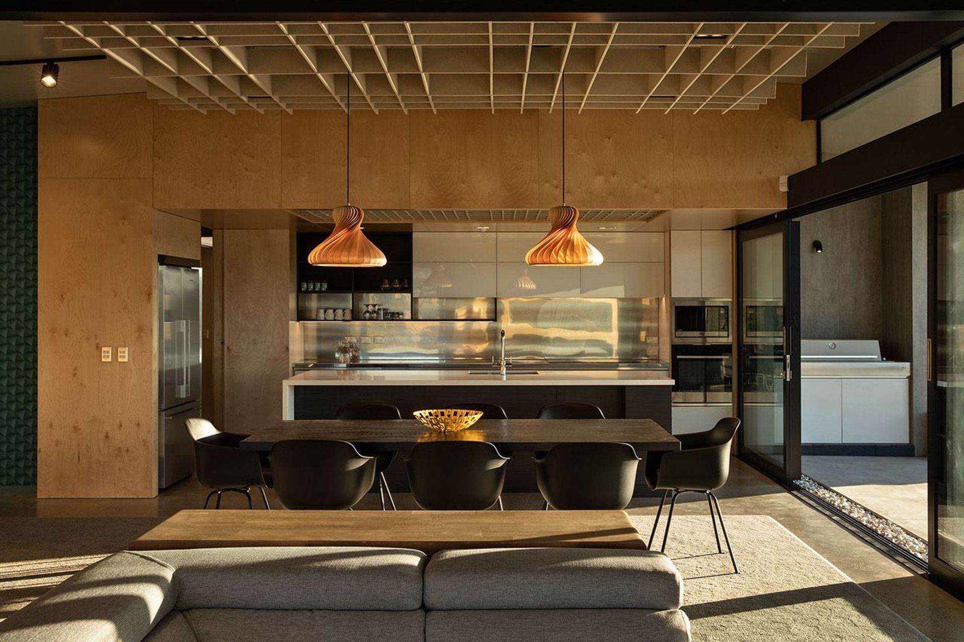 The ceiling height in the dining room compresses in the kitchen to create more drama througout this open-plan space. Photograph: Simon Devitt.