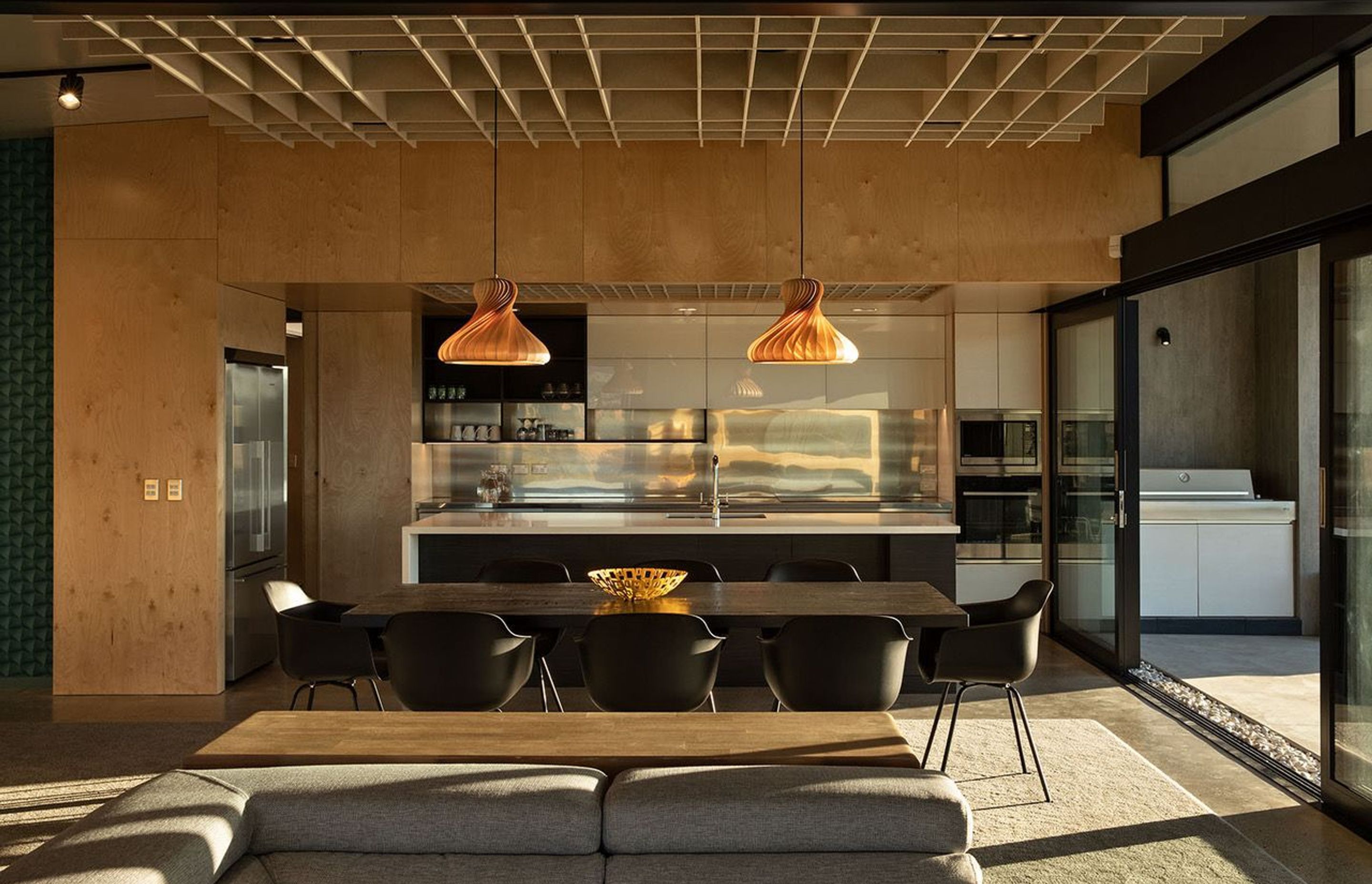 The ceiling height in the dining room compresses in the kitchen to create more drama througout this open-plan space. Photograph: Simon Devitt.