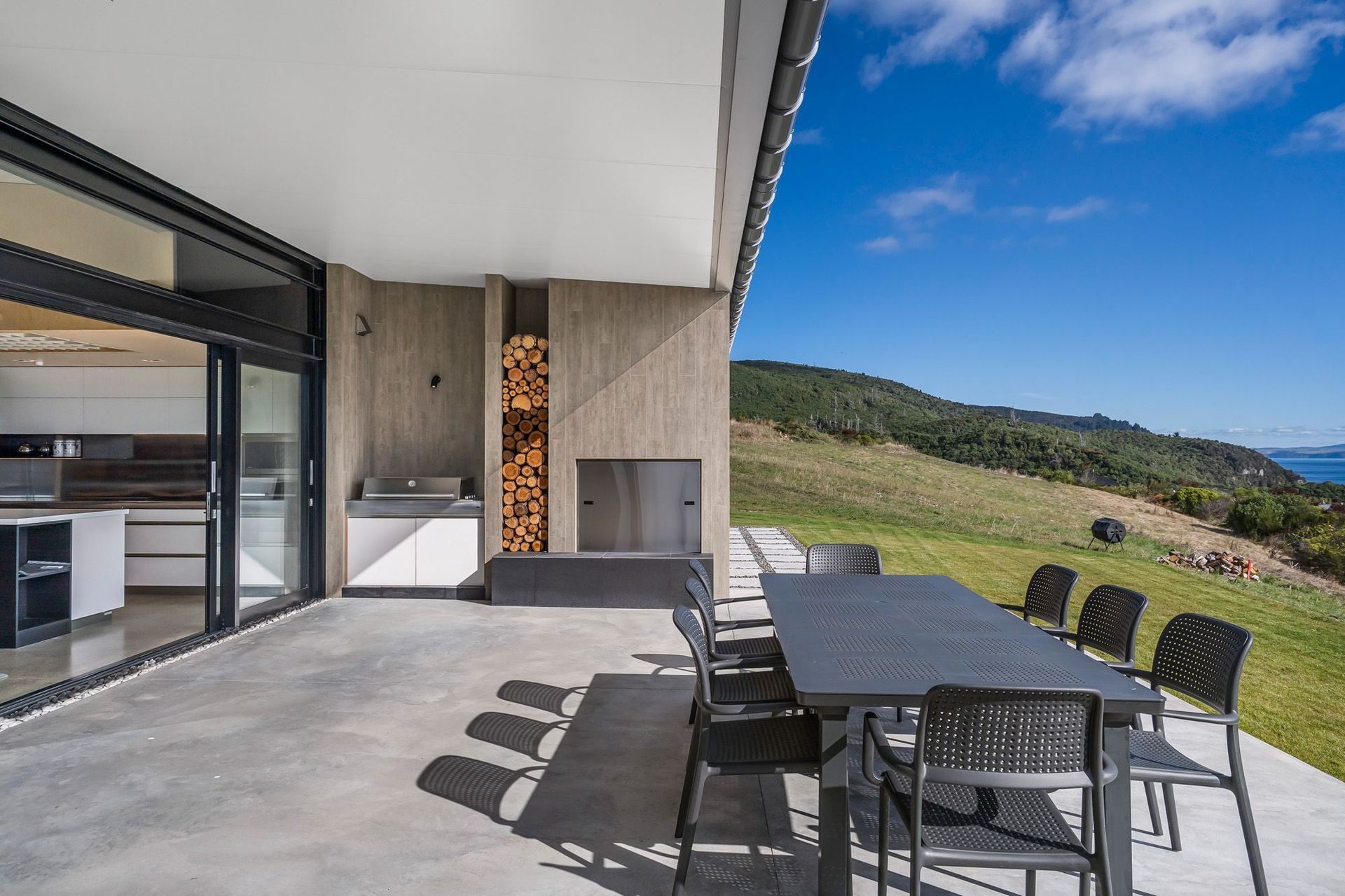 The outside kitchen, BBQ and dining area expands into lawn and overlooks Lake Taupo. Photograph: ArchiPro