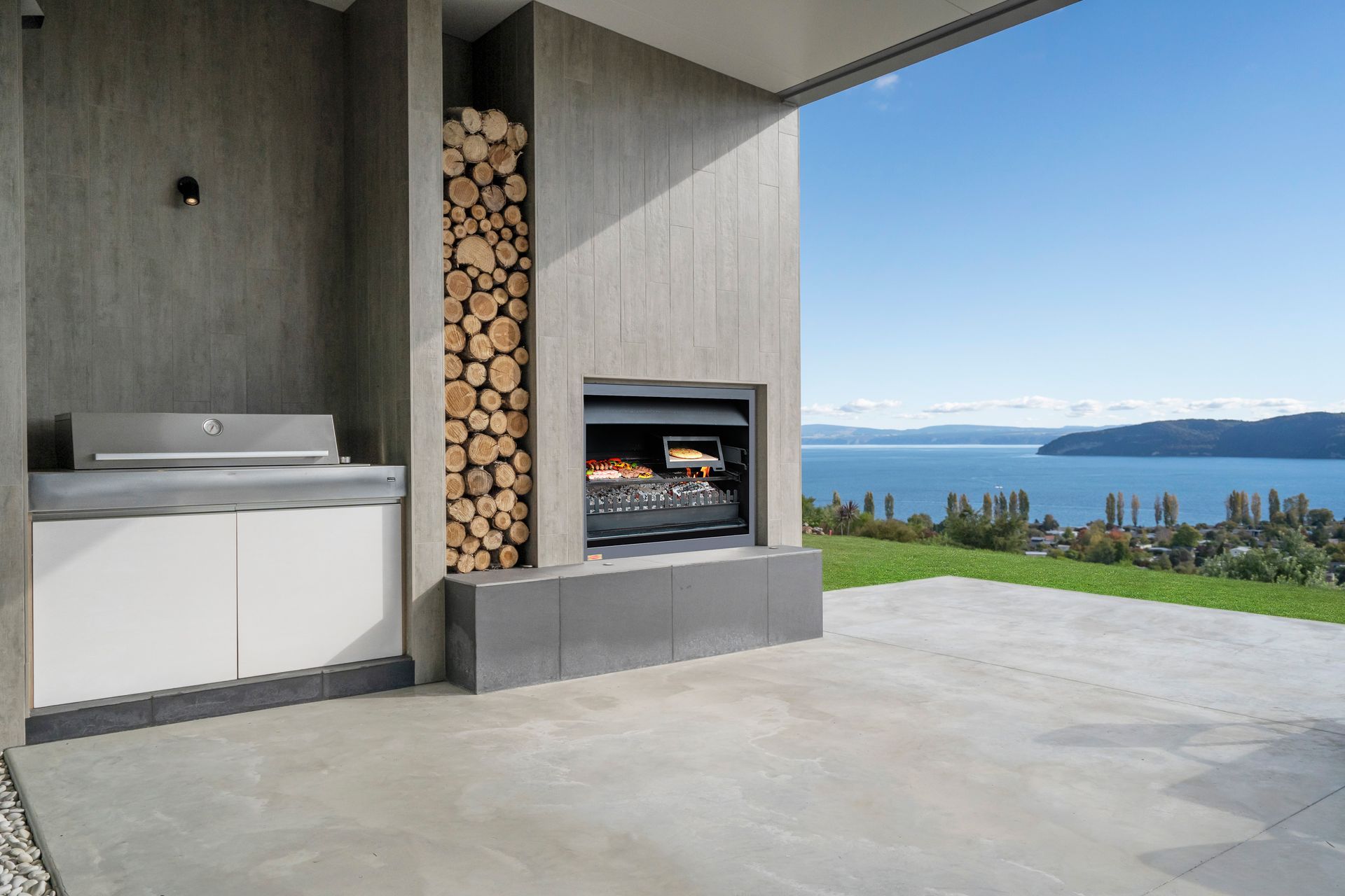 The outside kitchen, BBQ and dining area expands into lawn and overlooks Lake Taupo. Photograph: ArchiPro
