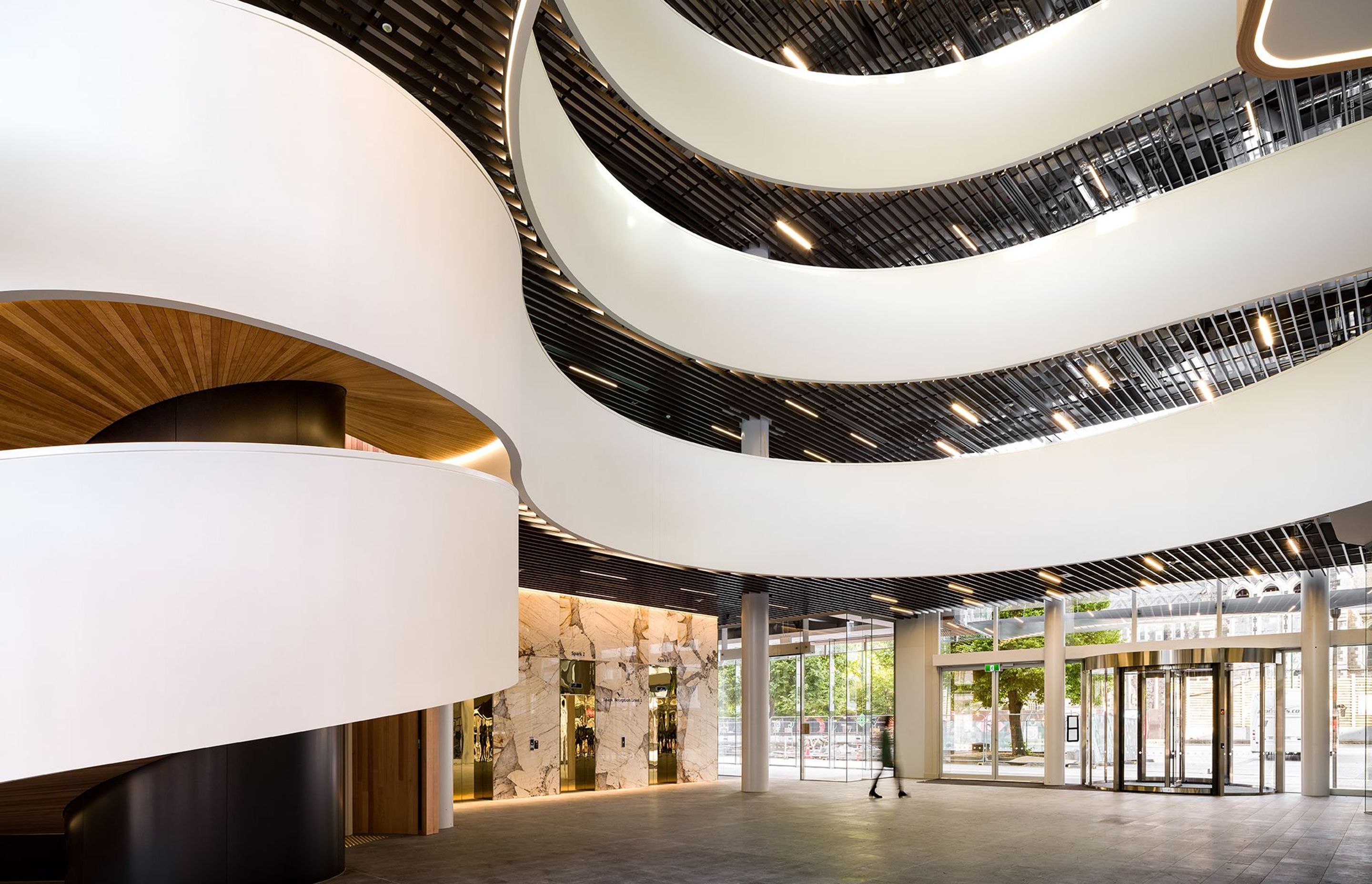 The staircase appears like a streaming white ribbon that curls around the atrium space and up the building, before it ends on the fifth-floor.