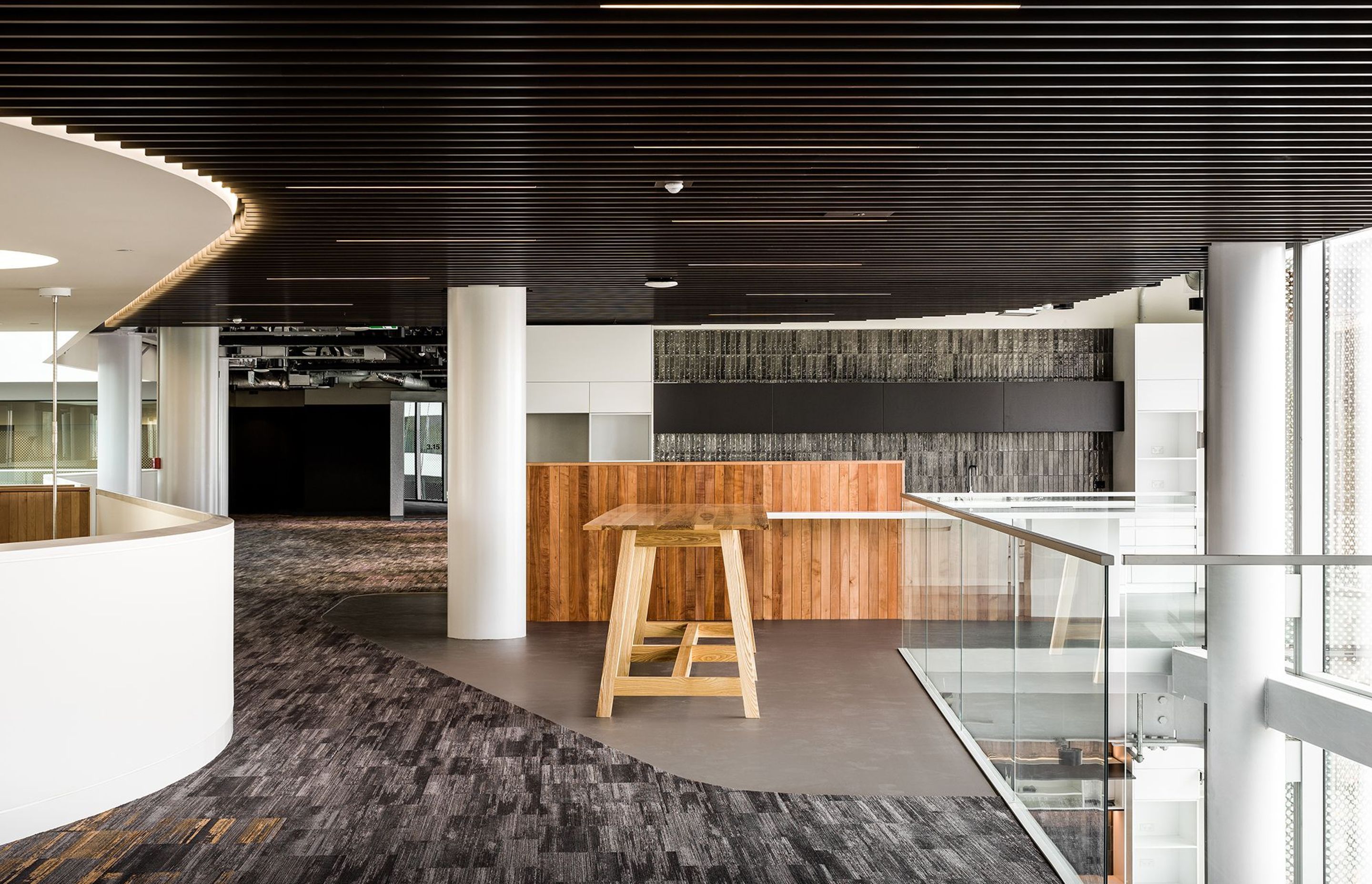 A shared kitchen on one of the floors incorporates a more residential palette of timber panelling and subway tiles to make the office space more warm and inviting.