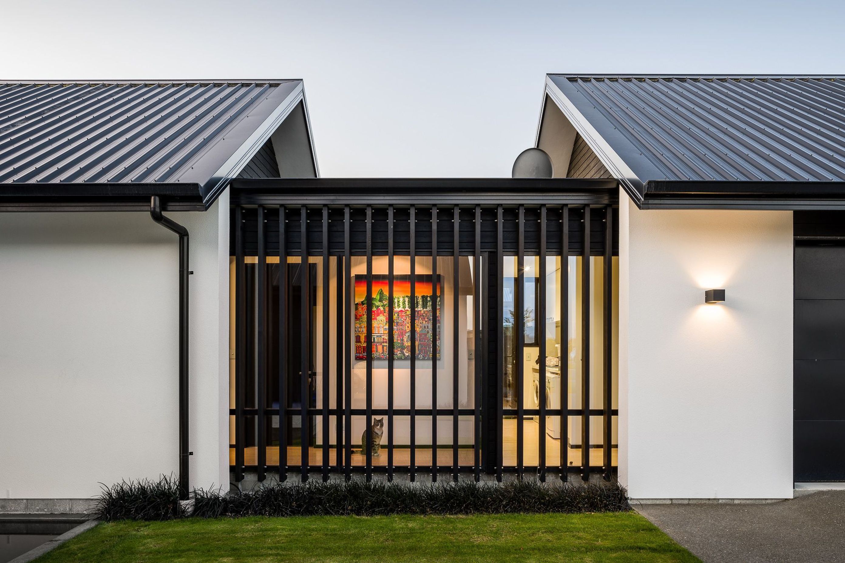 A small, glazed corridor element links the garage with the house proper providing visual interest by breaking up the plane of cladding.