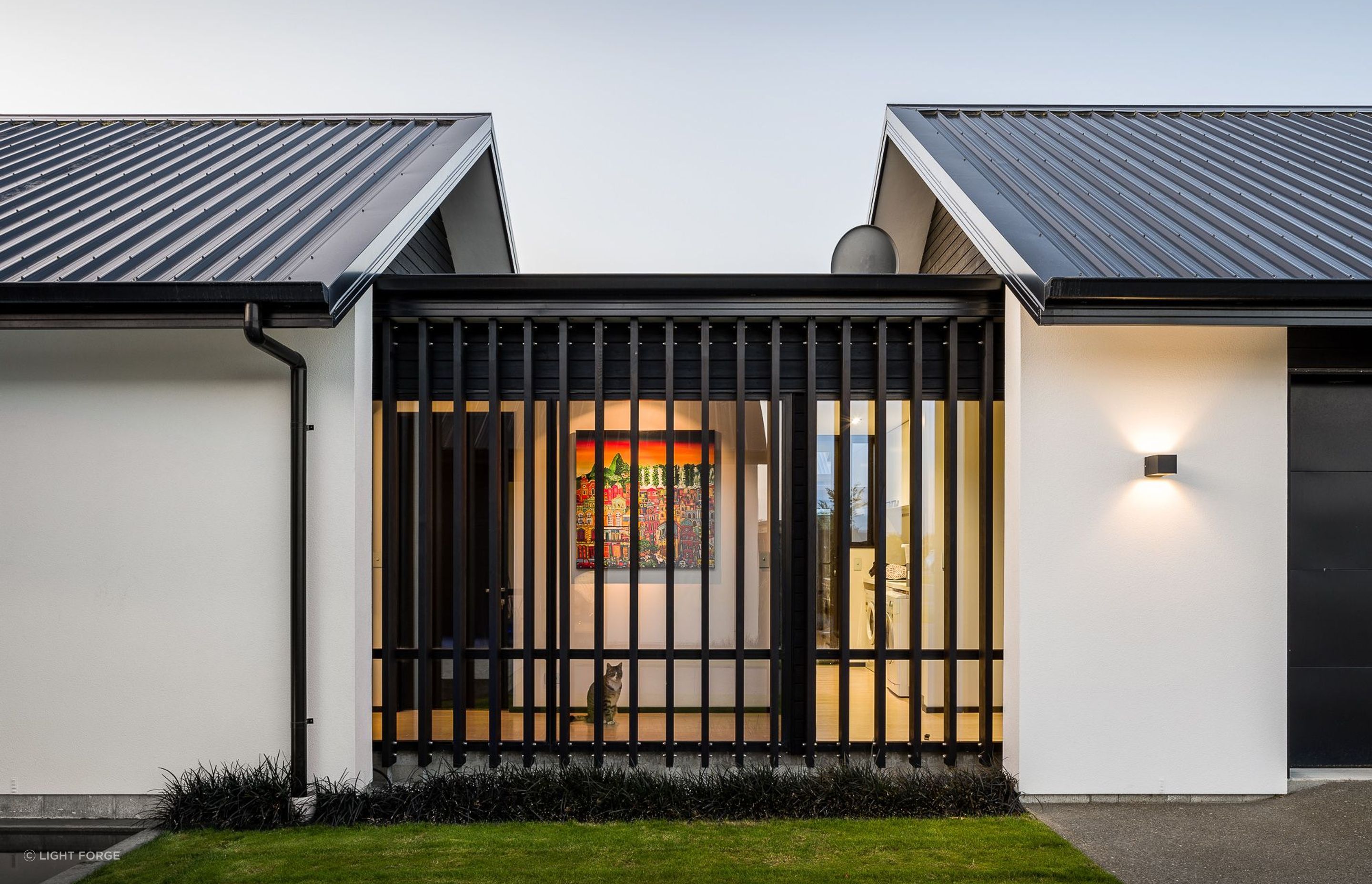 A small, glazed corridor element links the garage with the house proper providing visual interest by breaking up the plane of cladding.