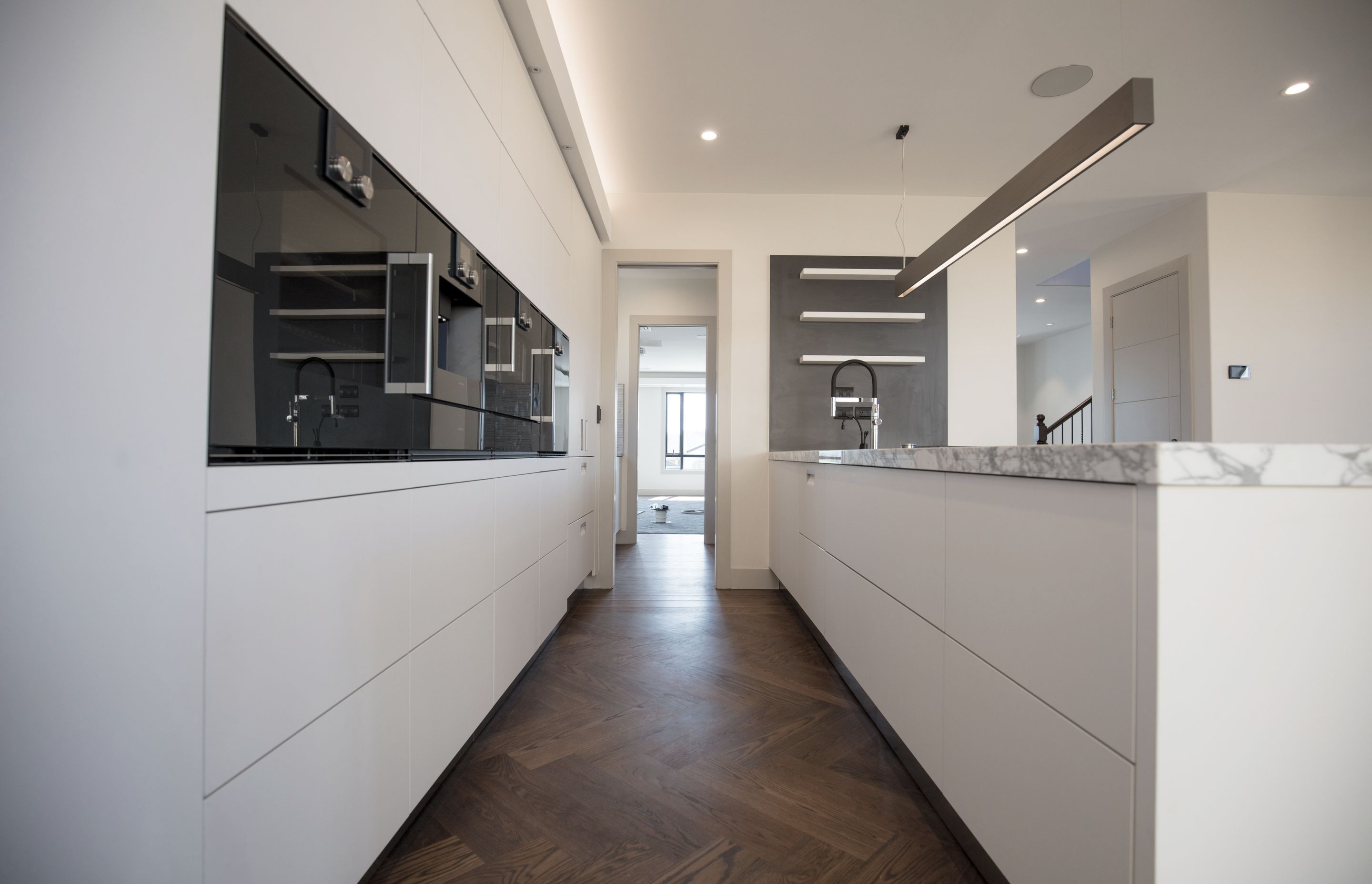 Lagonda Rise - Prime Grade Solid American White Oak in Herringbone Parquet w/ a two plank border and finished with a stain in 'Jacobean' and Waterborne Polyurethane