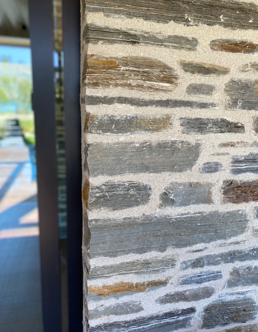 The Matte Flaxpod finish on the joinery and louvres works with natural warmth of schist
