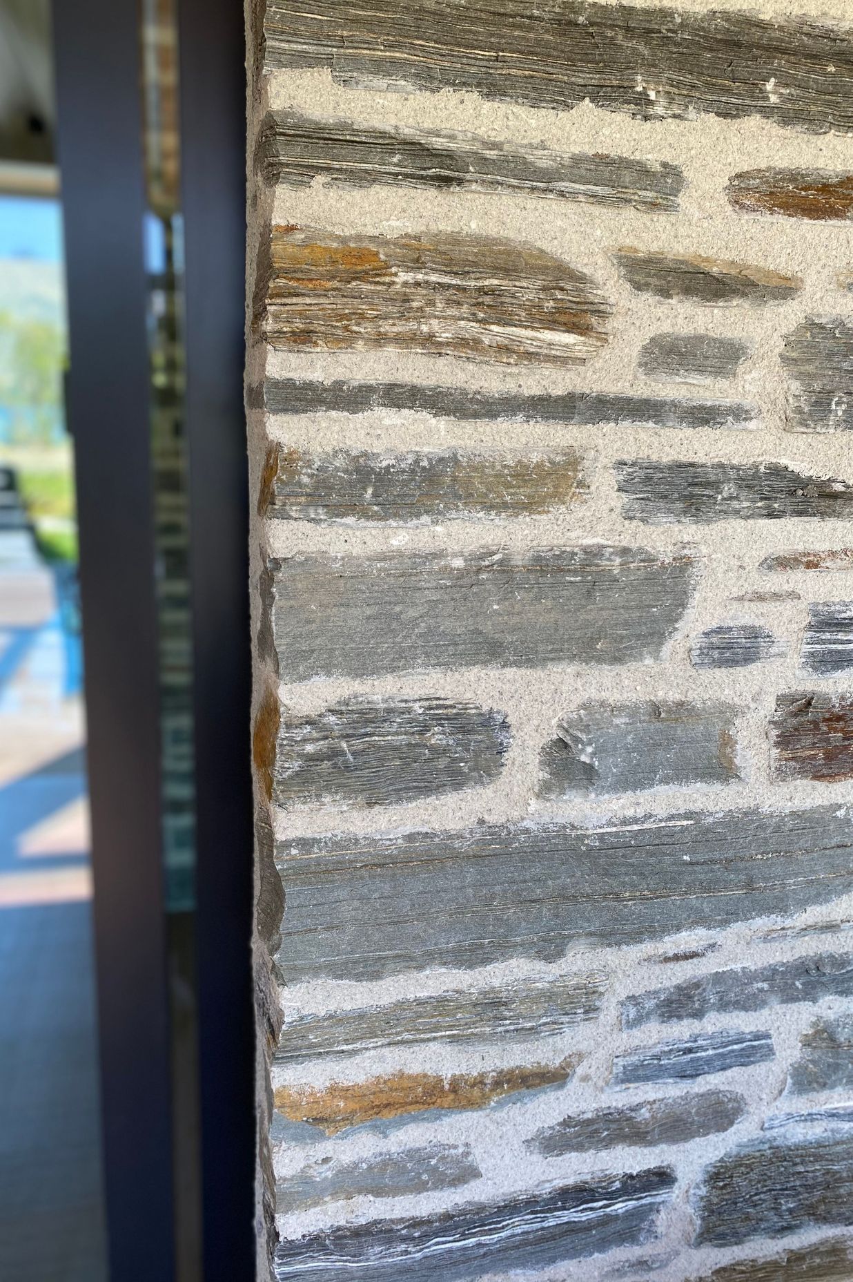 The Matte Flaxpod finish on the joinery and louvres works with natural warmth of schist