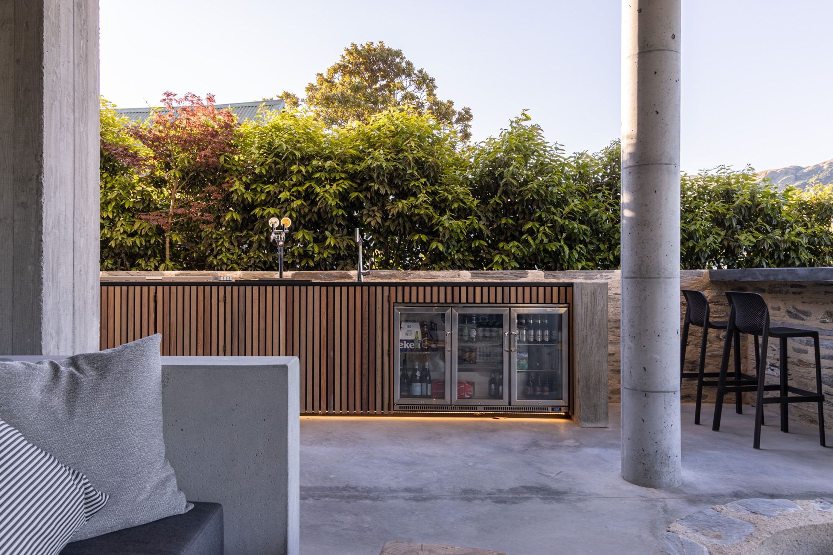 The bespoke cedar, schist and concrete bar has built-in wine and beer fridges and has bar seating that looks out to the lake and mountains.