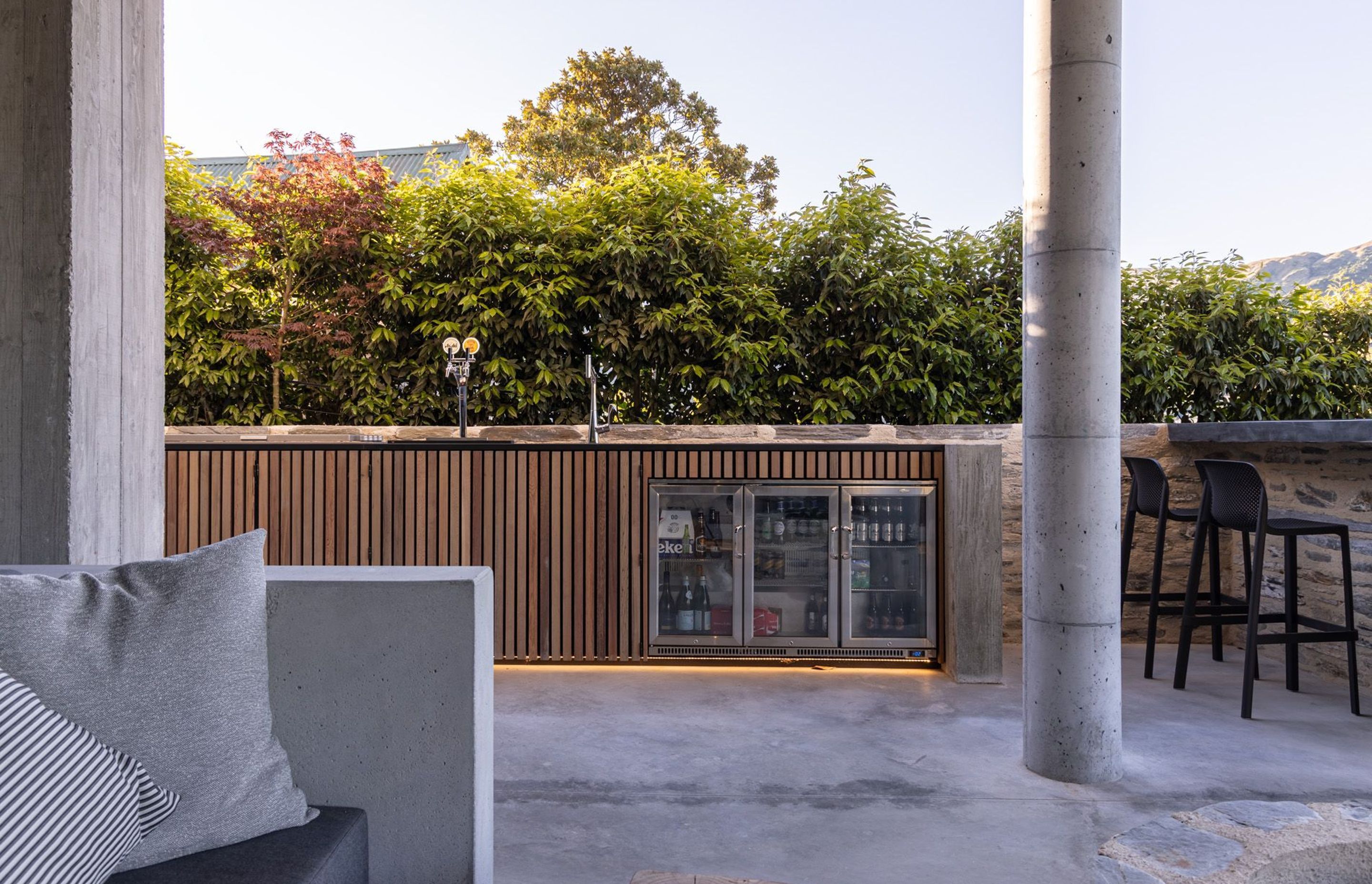 The bespoke cedar, schist and concrete bar has built-in wine and beer fridges and has bar seating that looks out to the lake and mountains.