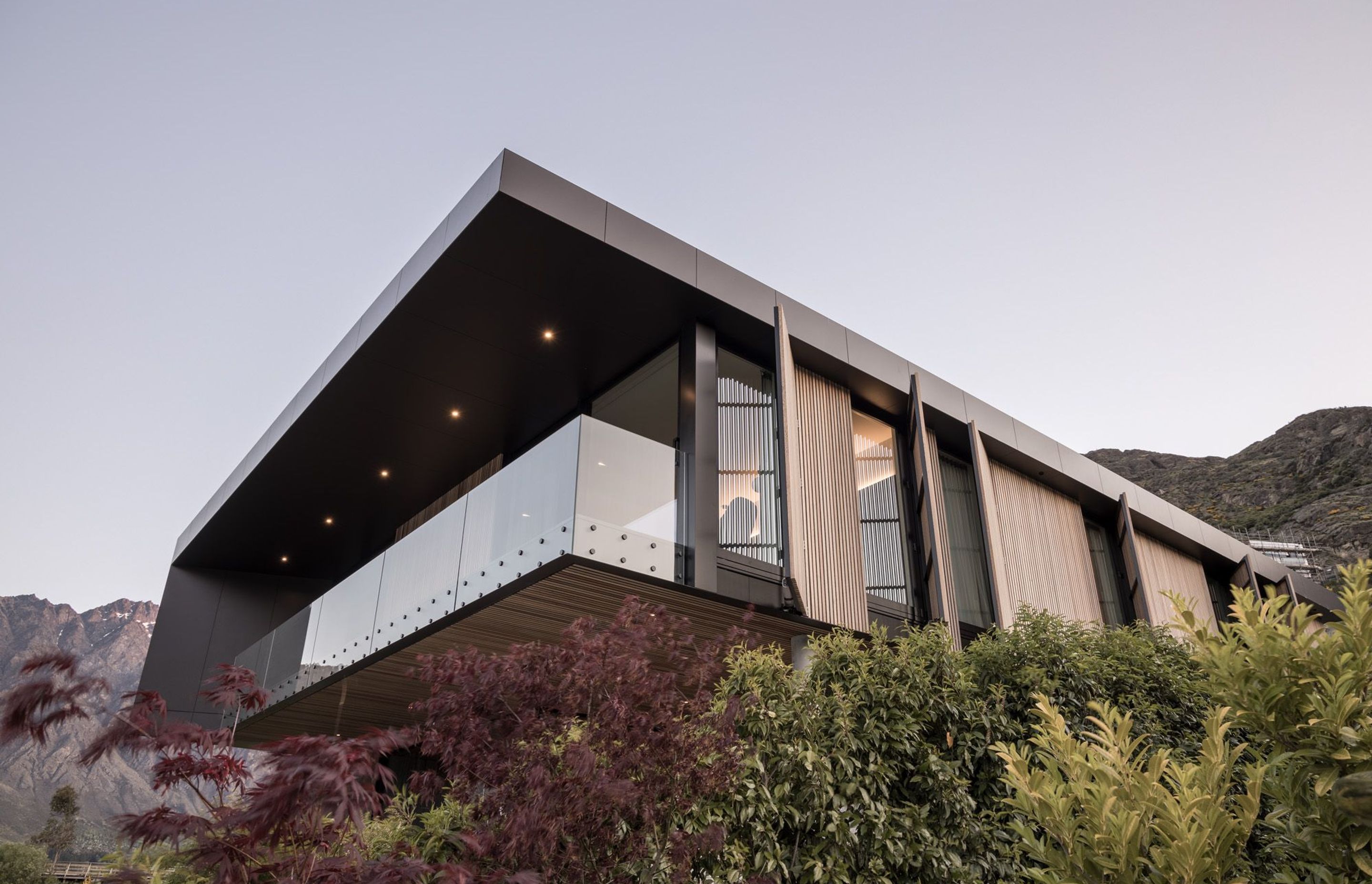 A ‘big box over a little box’ concept has created a cedar box that flies out over an outdoor room, with activated cedar screens on the side to create privacy from the neighbouring hotel.