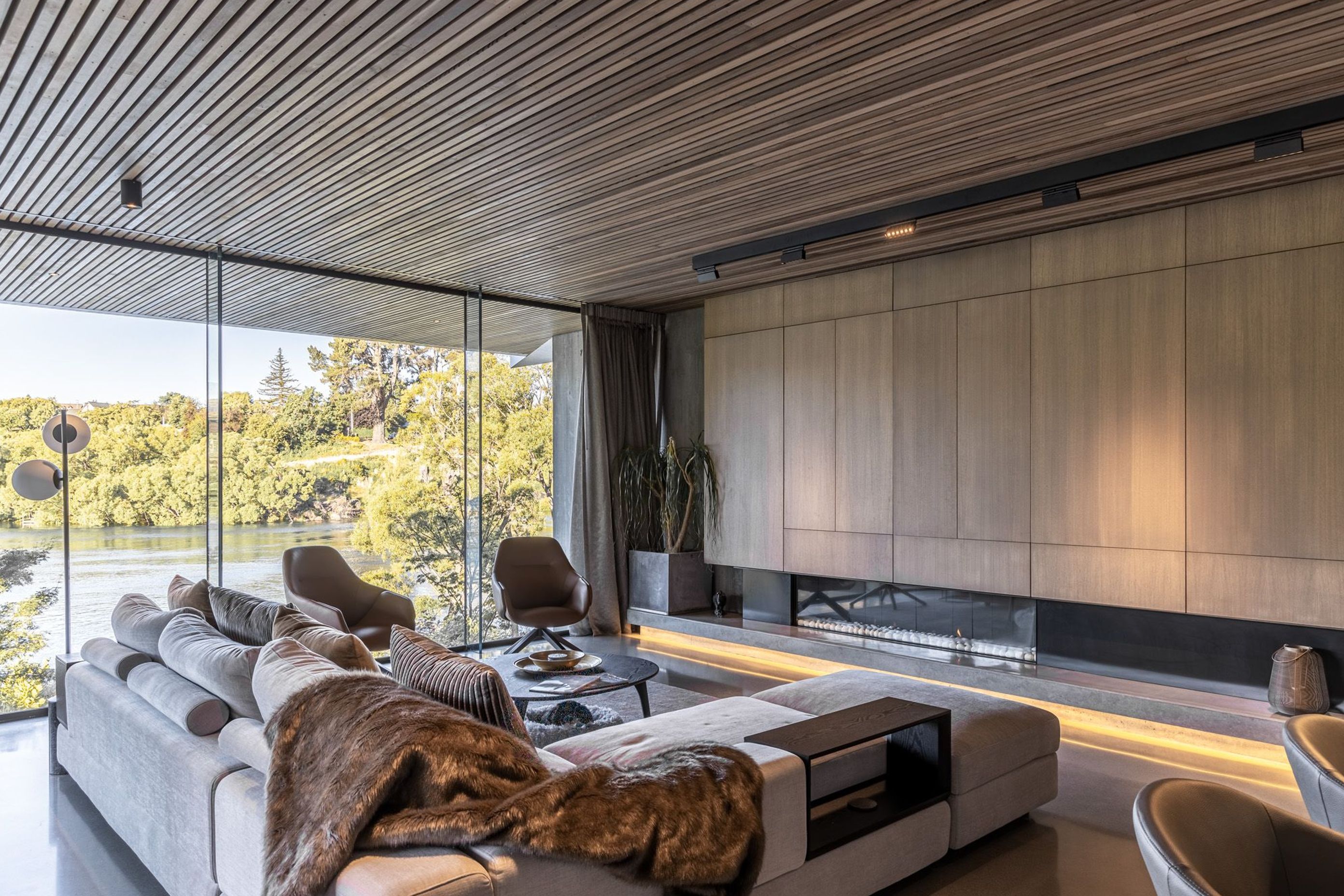 Cedar-panelled ceilings in the living spaces continue through the glass, helping to connect the inside with the stunning surrounding landscape.
