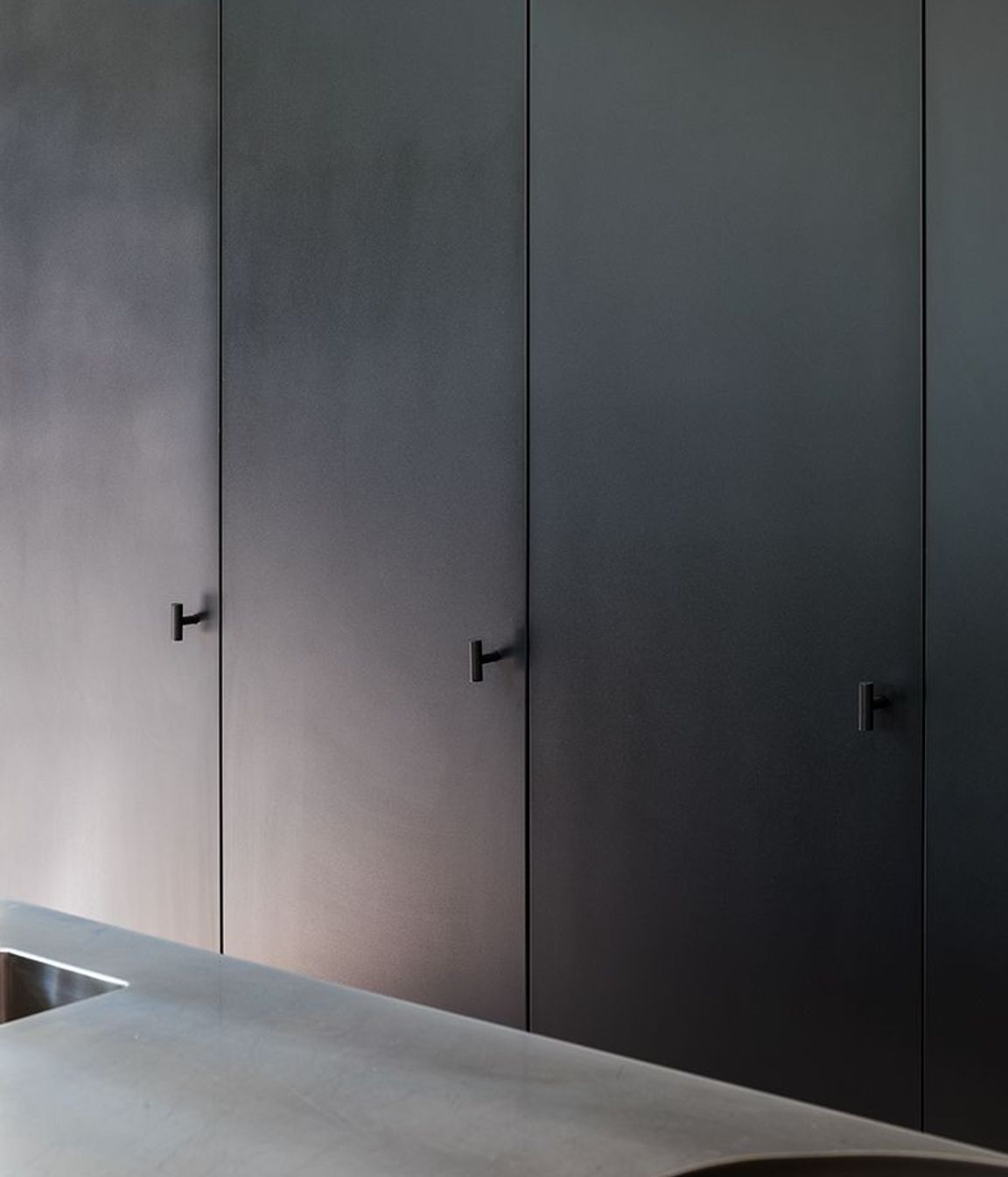 Custom made cabinet handles cleanly integrate with the rear wall full-height cabinets.