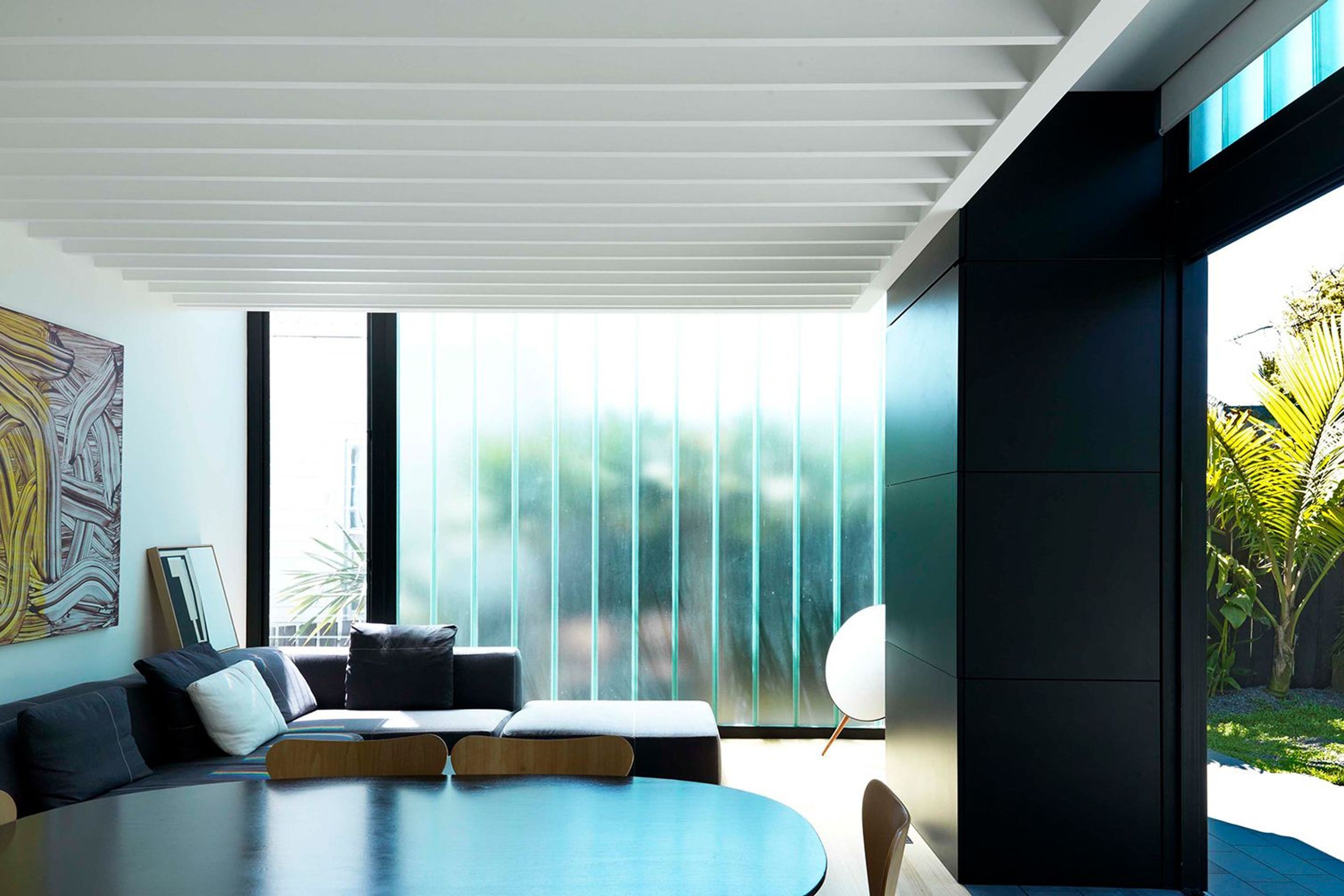 A BBQ unit is concealed behind a vertical bi-folding enclosure, clad in black steel. To the reverse side of the BBQ unit, a TV cabinet is similarly concealed to the interior.