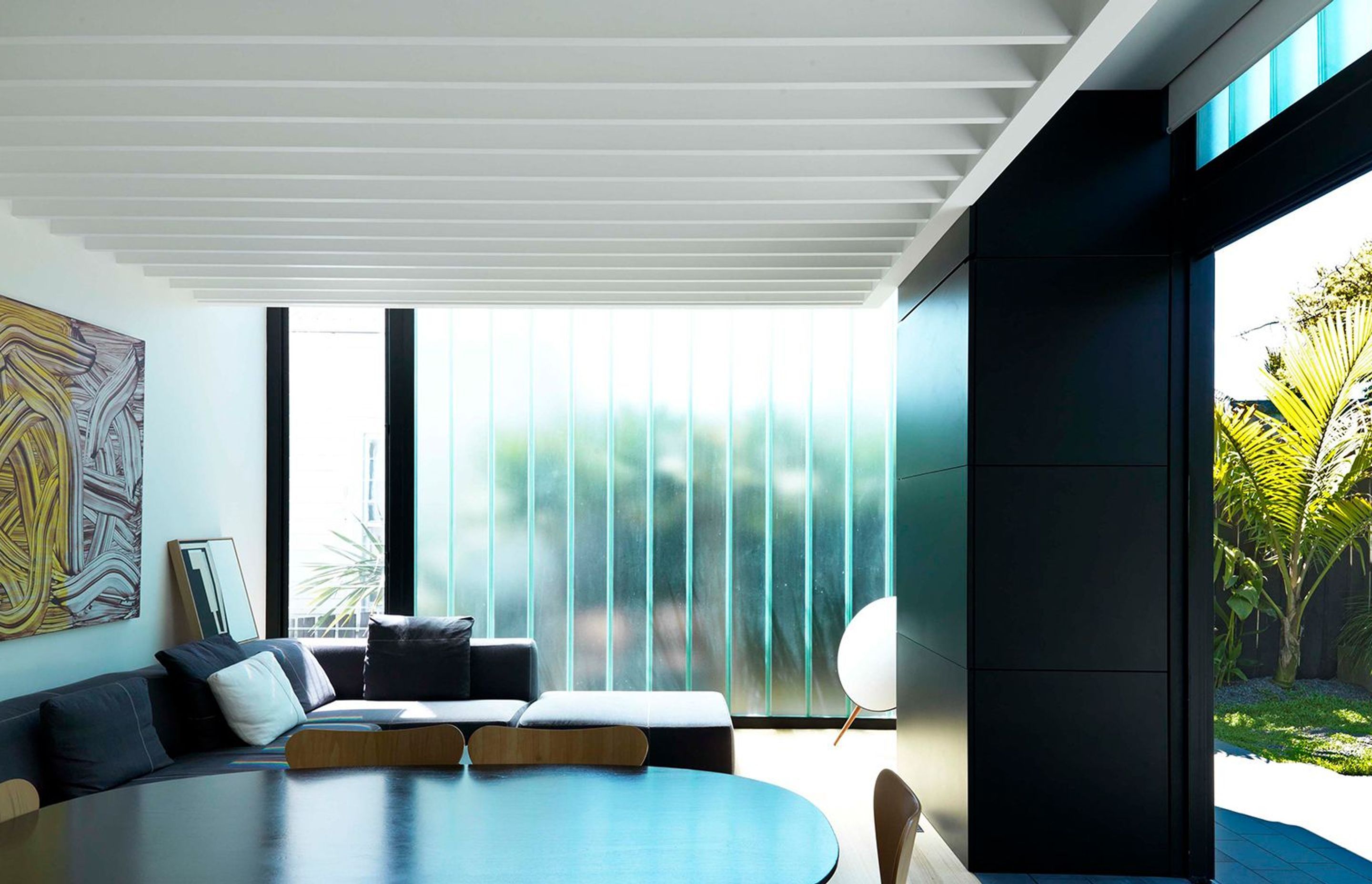 A BBQ unit is concealed behind a vertical bi-folding enclosure, clad in black steel. To the reverse side of the BBQ unit, a TV cabinet is similarly concealed to the interior.