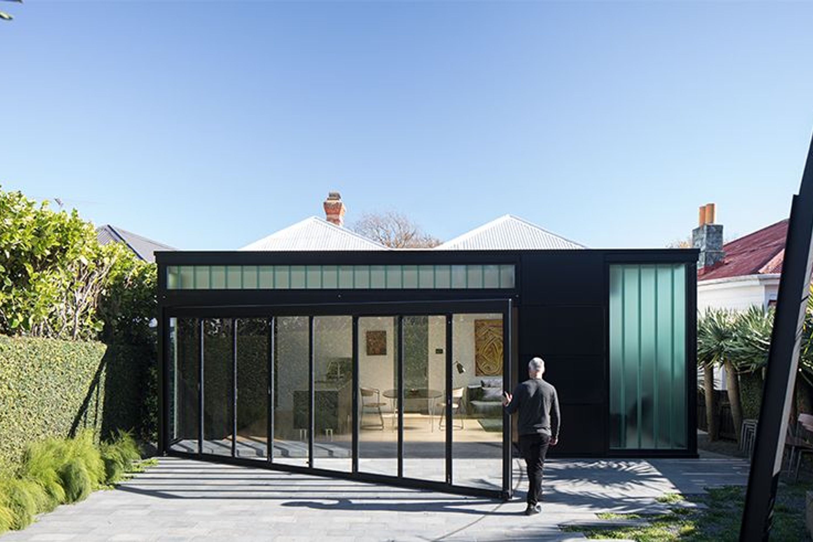 At the rear of the villa is the Lightbox addition, a dramatic contemporary contrast to the detail and filigree of the existing villa. Here, Ken closes the wall tha opens into the backyard.
