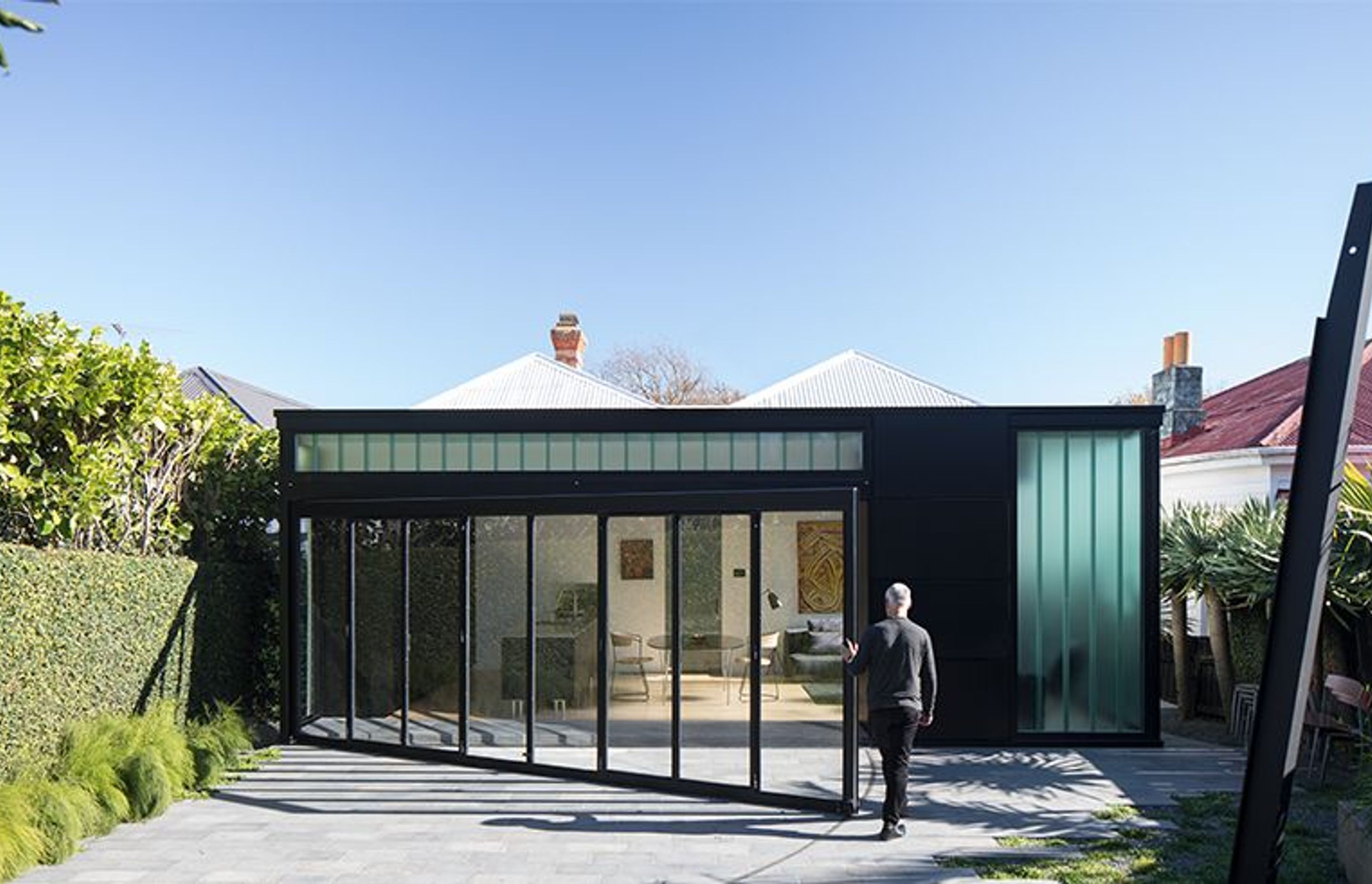 At the rear of the villa is the Lightbox addition, a dramatic contemporary contrast to the detail and filigree of the existing villa. Here, Ken closes the wall tha opens into the backyard.