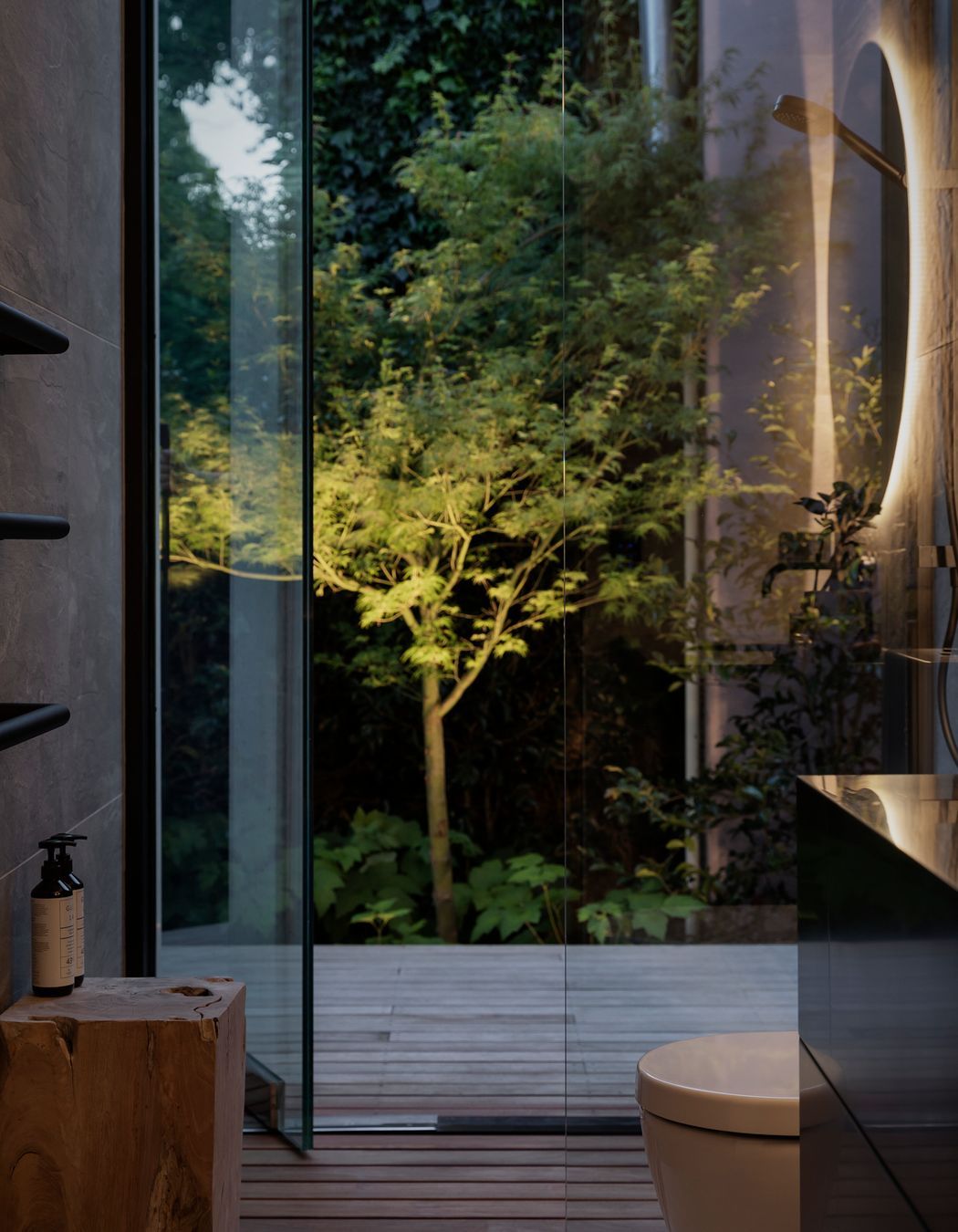 A maple tree in the adjacent bathroom forms a  sculptural form lit up at night.