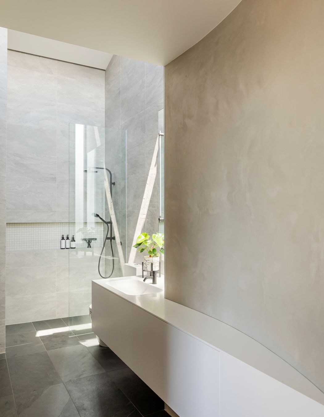 The ensuite bathroom maximises the internal curves formed by the curved garage walls.
