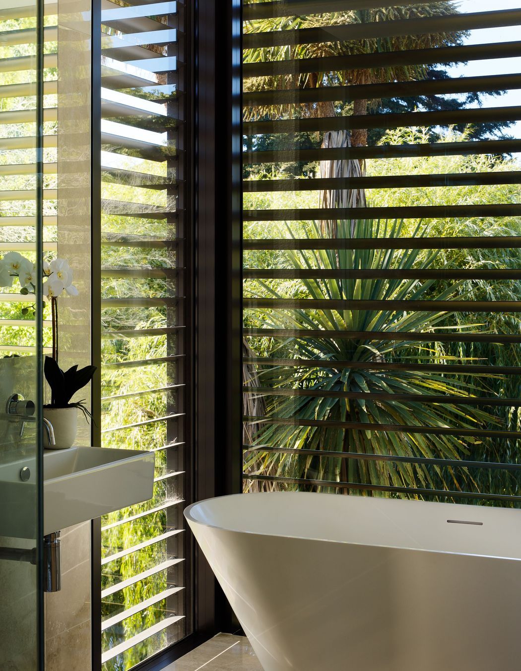 Black aluminium louvres contrast the cedar and plastered block of the exterior. 