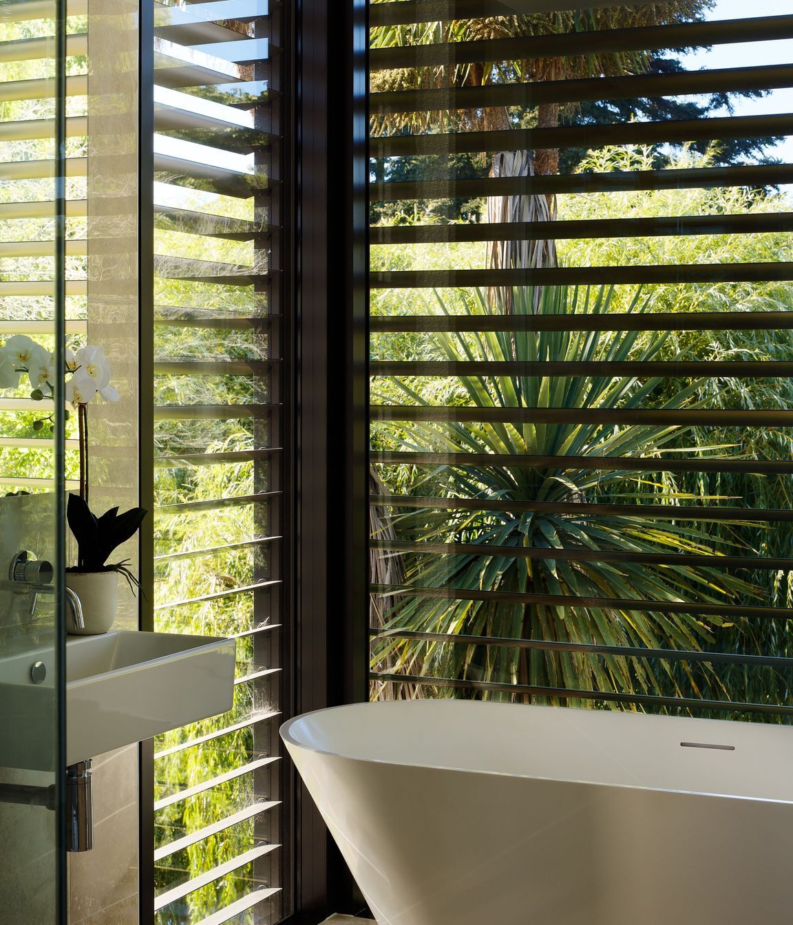 Black aluminium louvres contrast the cedar and plastered block of the exterior. 